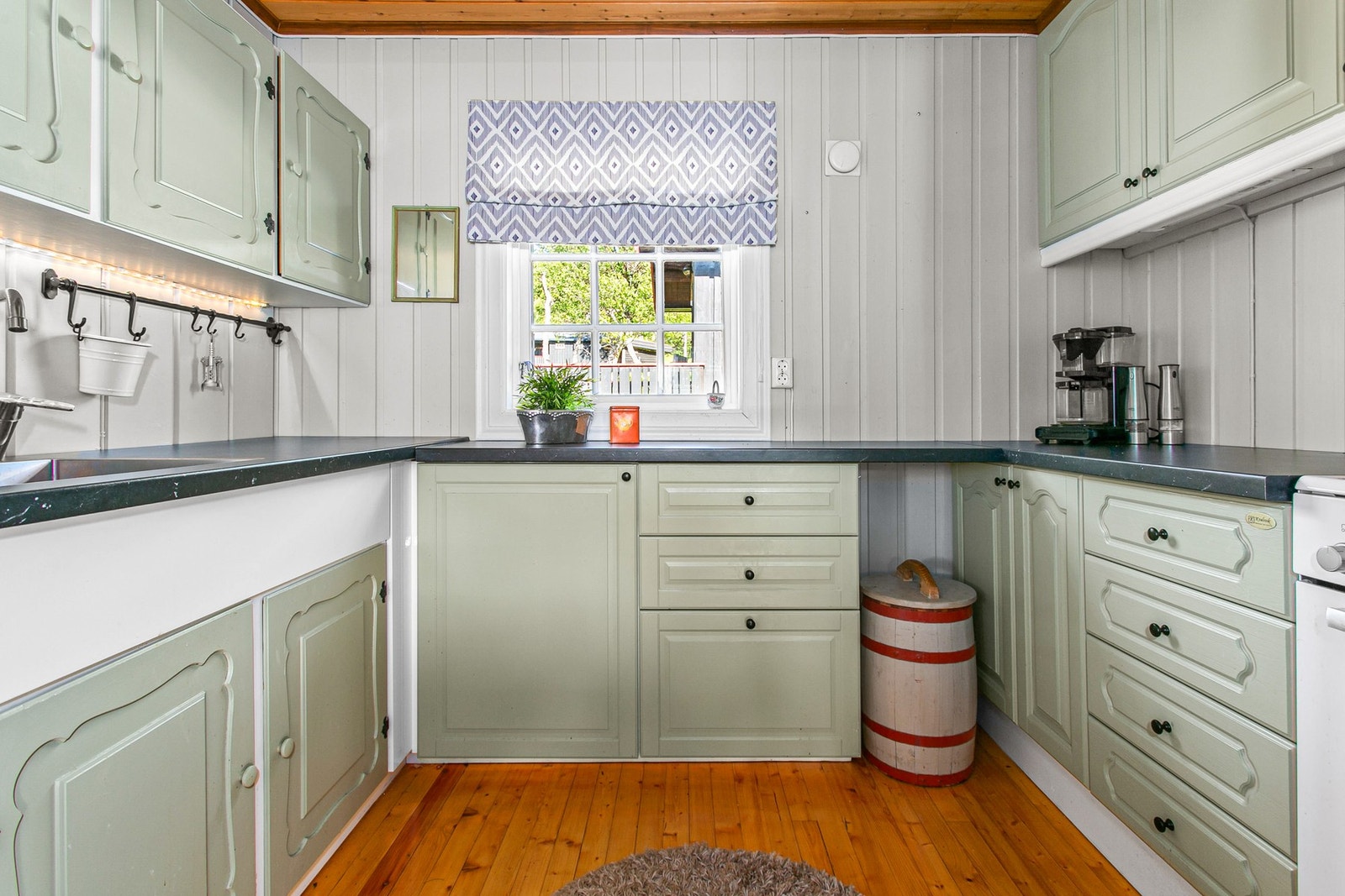 Kjøkken med mye skap -og benkeplass. Galleribilde