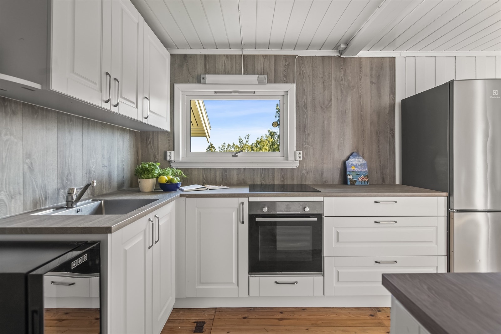 Moderne kjøkkeninnredning fra 2018 med profilerte fronter. Det er godt med skap - og benkeplass. Laminatplate mellom benkeplate og overskap. Integrert oppvaskmaskin, induksjonstopp, stekeovn og frittstående kjøleskap medfølger. Galleribilde