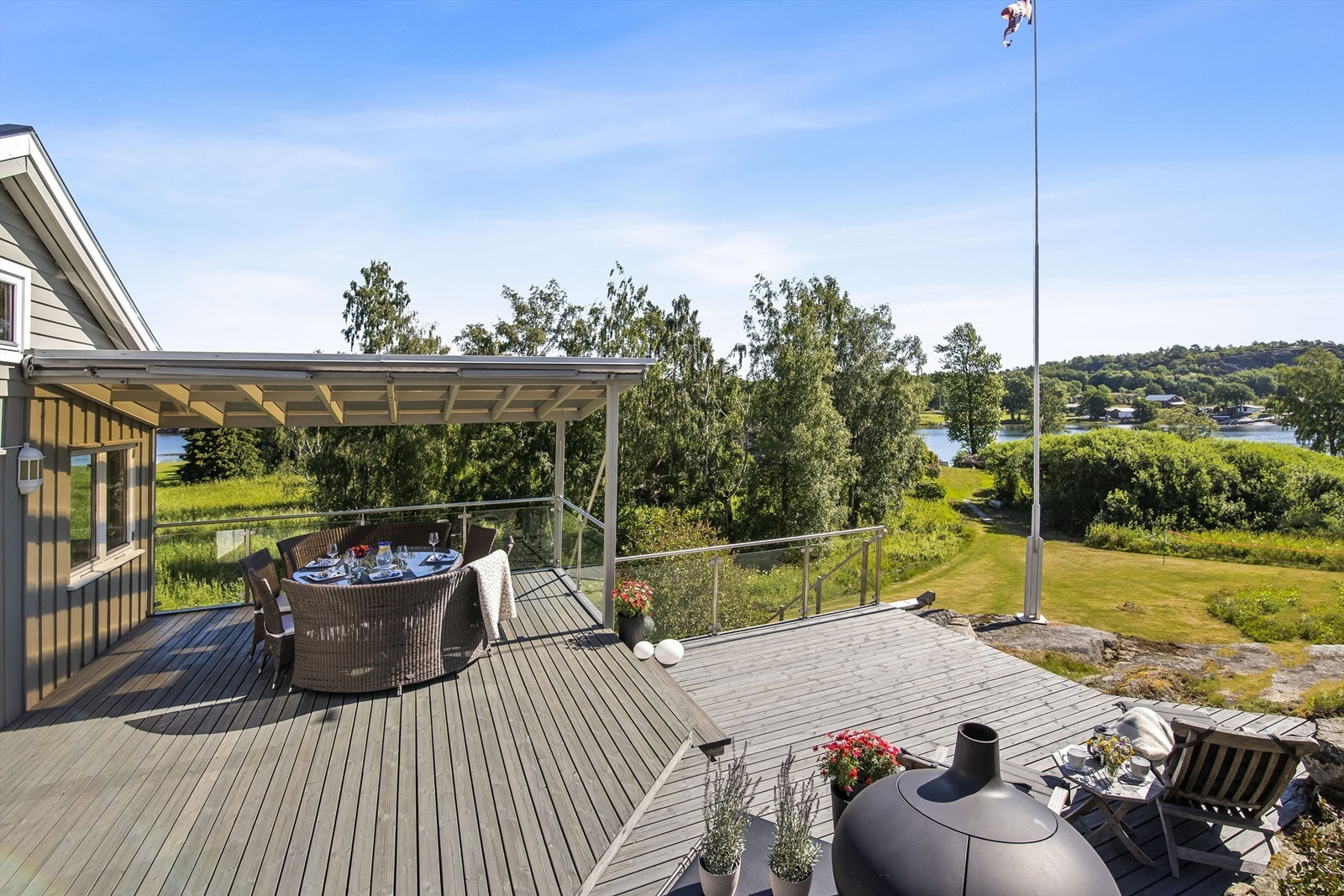 Mot sjøen og det åpne landskapet i øst/syd er det bygget stor terrasse, her får du også nydelig utsikt og du sitter lunt og usjenert til da deler av plassen også er overbygget (ikke søkt og godkjent). Galleribilde