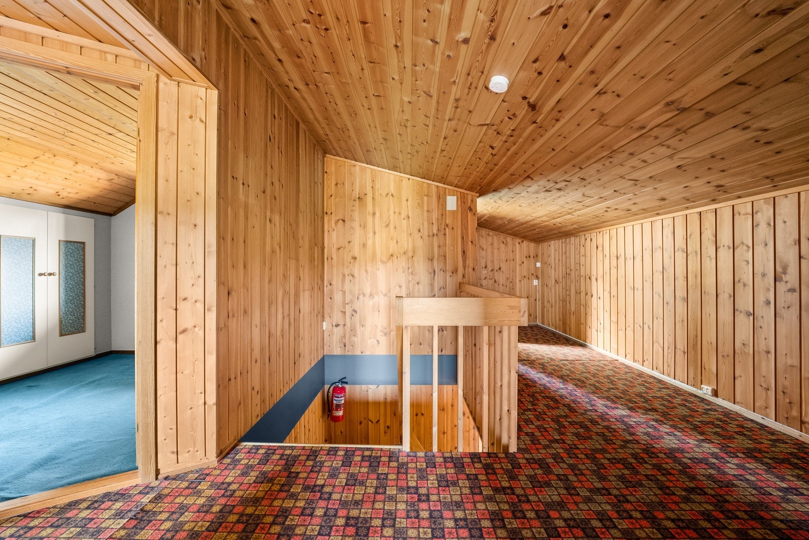 Gang i 2 etg med friske farger i teppet på gulv og panel på vegger og tak. Galleribilde