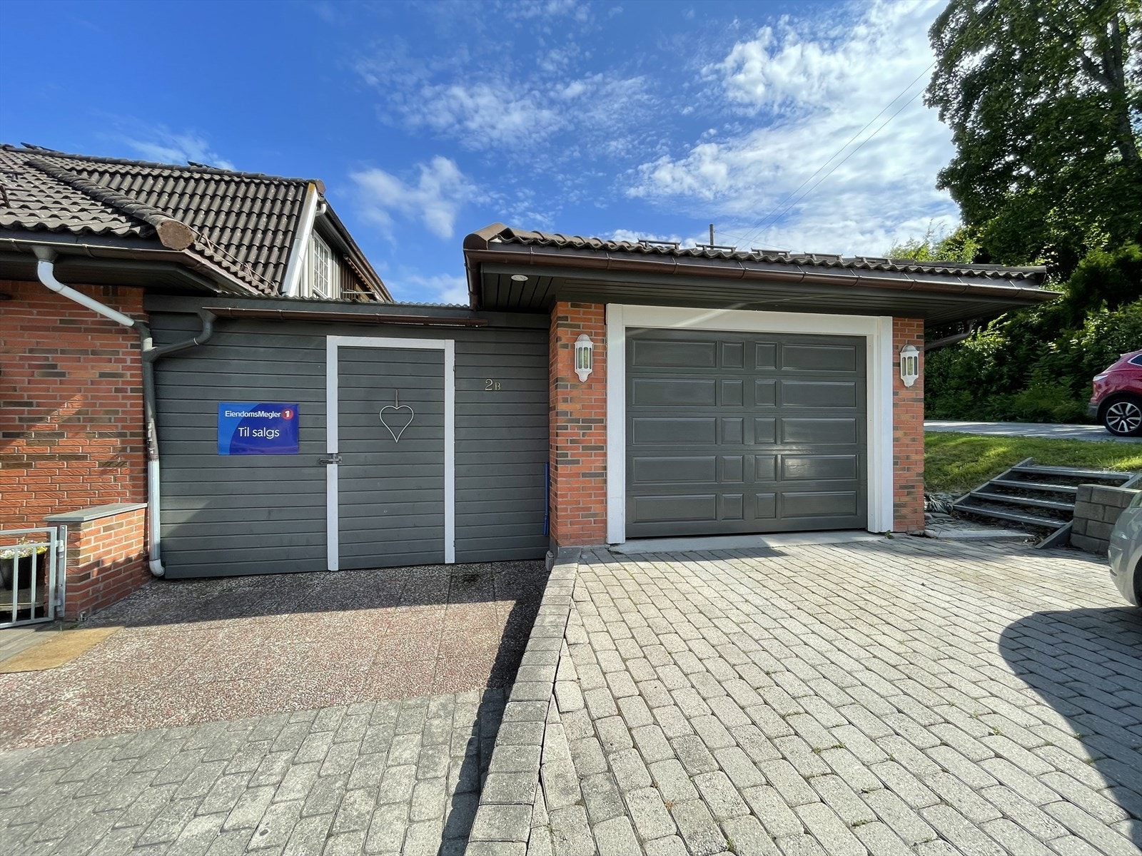 Boligens hoveddel har et lunt og trivelig inngangsparti med port, og en romslig gårdsplass med parkering i tillegg til garasje Galleribilde