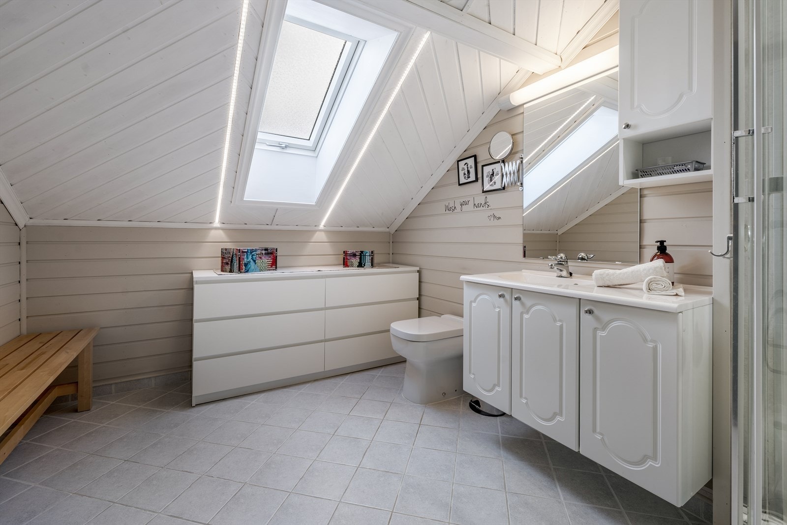 Badet i 2. etasje har fliser på gulv med varmekabler, og det tilføres godt med dagslys via takvindu. På veggoverflater er det malt panel og baderomsplater. Badet er overflatemodernisert i 2017 hvor det også ble lagt ny varmekabel. Galleribilde