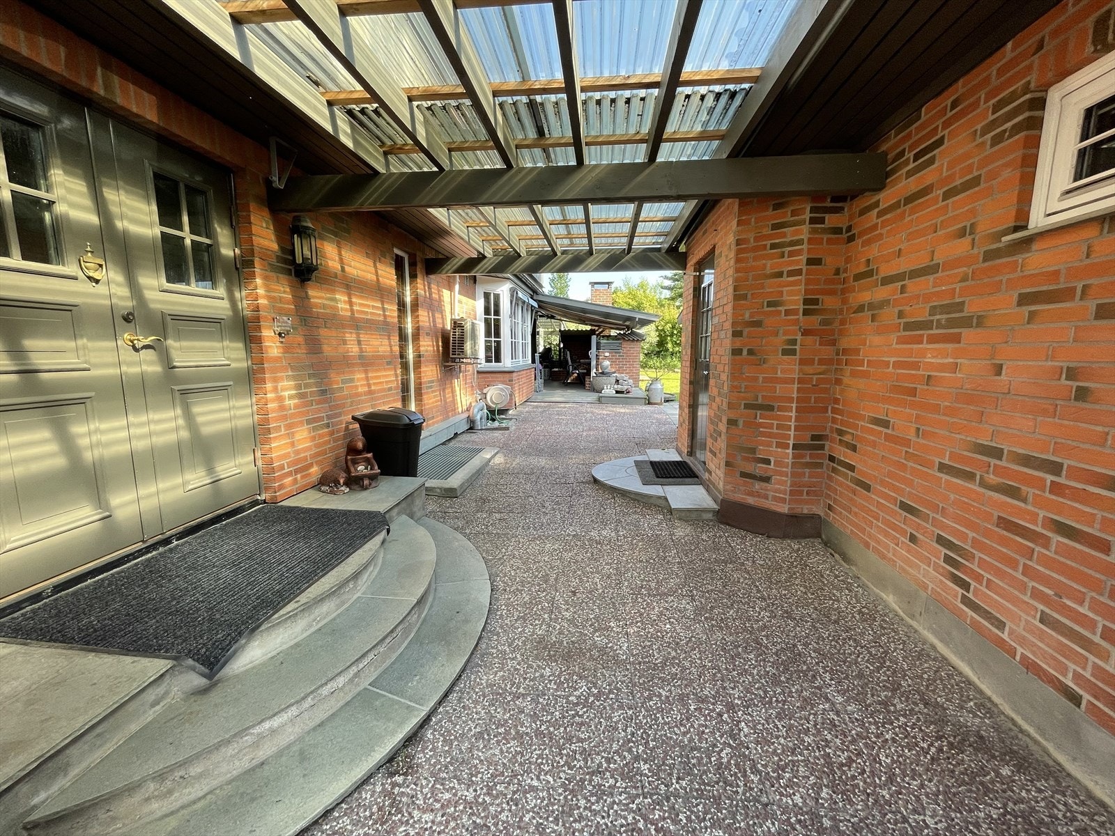 Lukket, overbygd gårdsrom med adkomst til hoveddelen, samt til garasjen og uteplasser Galleribilde