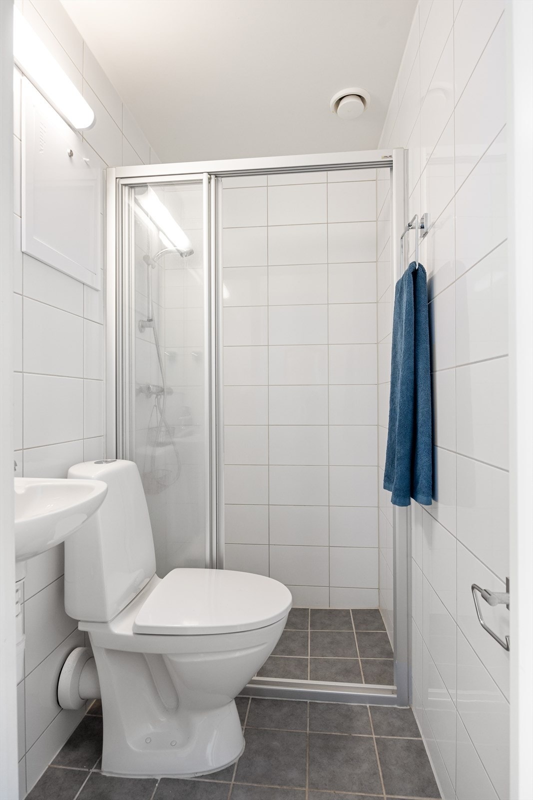 Delikat flislagt baderom fra 2014 med varmekabler i gulv. Badet består av wc, dusjplass med vegger og servant med ettgreps blandebatteri. Galleribilde