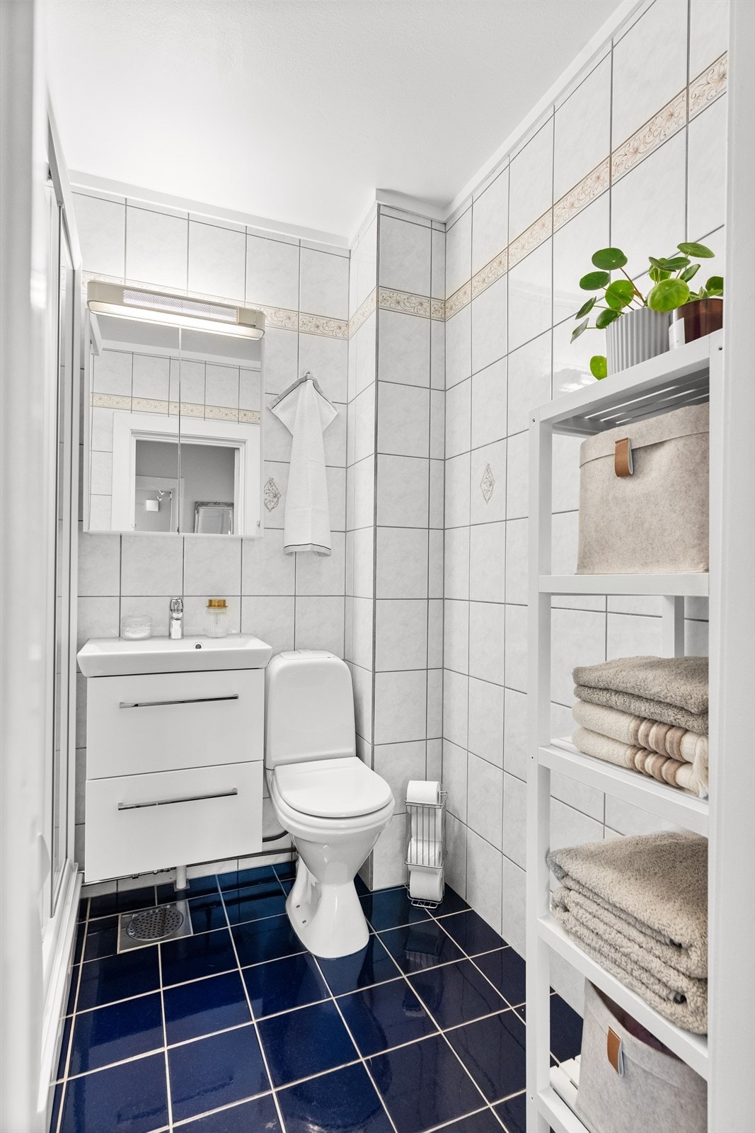 Gulv og vegger er flislagte, og rommet er innredet med dusjkabinett, klosett, servant og opplegg for vaskemaskin. Galleribilde