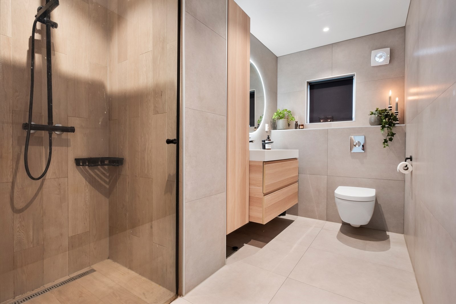 Lekkert bad oppusset i 2022. Bad med fliser og varmekabler på gulv, flis på vegger. Nedsenket dusjnisje med glassdør, veggmontert toalett, hel servantplate med underskap og 2 vannkraner. Elektrisk avtrekk på vegg. Galleribilde