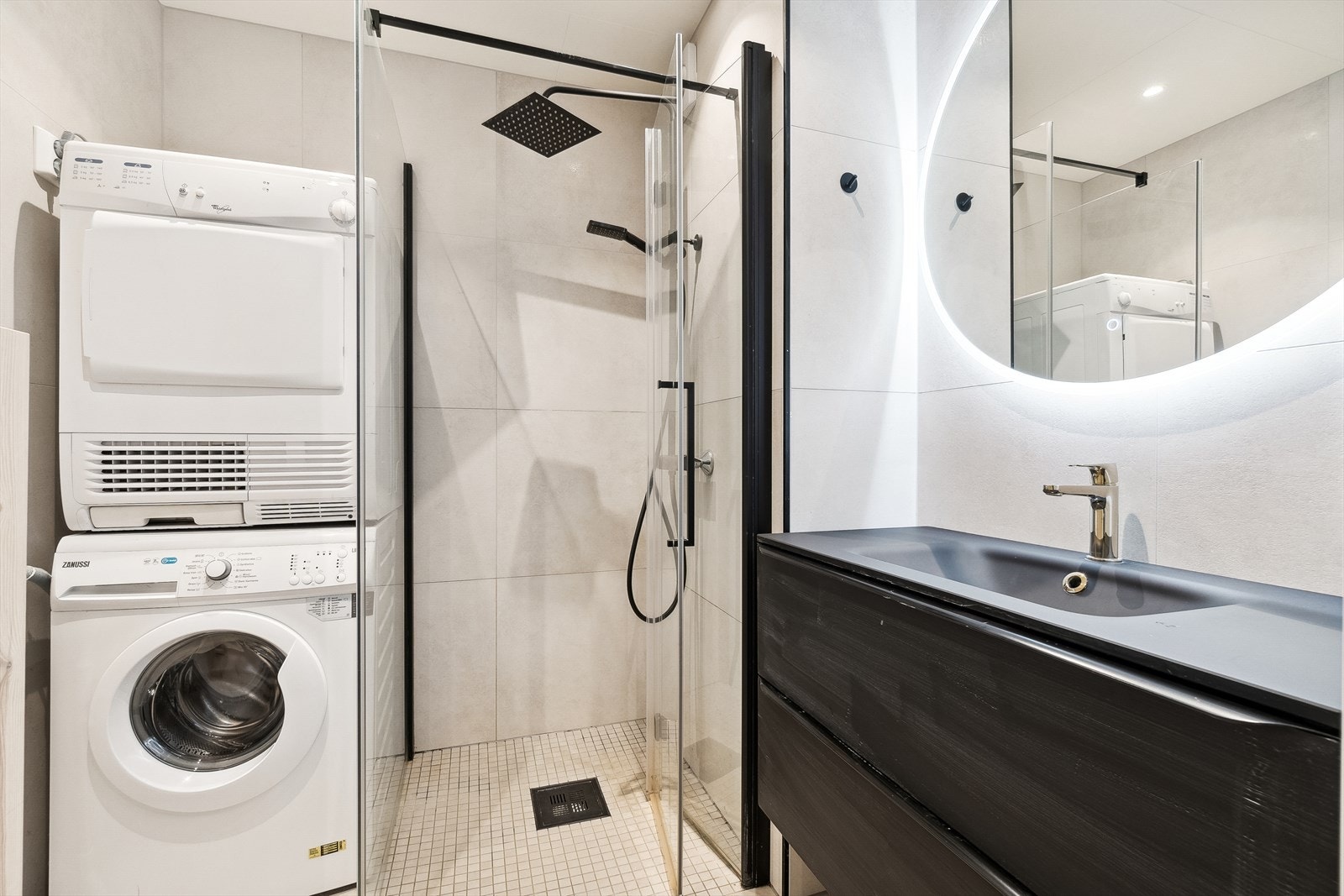 Delikat flislagt bad med varme i gulv, dusjhjørne og opplegg for vaskemaskin og tørketrommel. Galleribilde