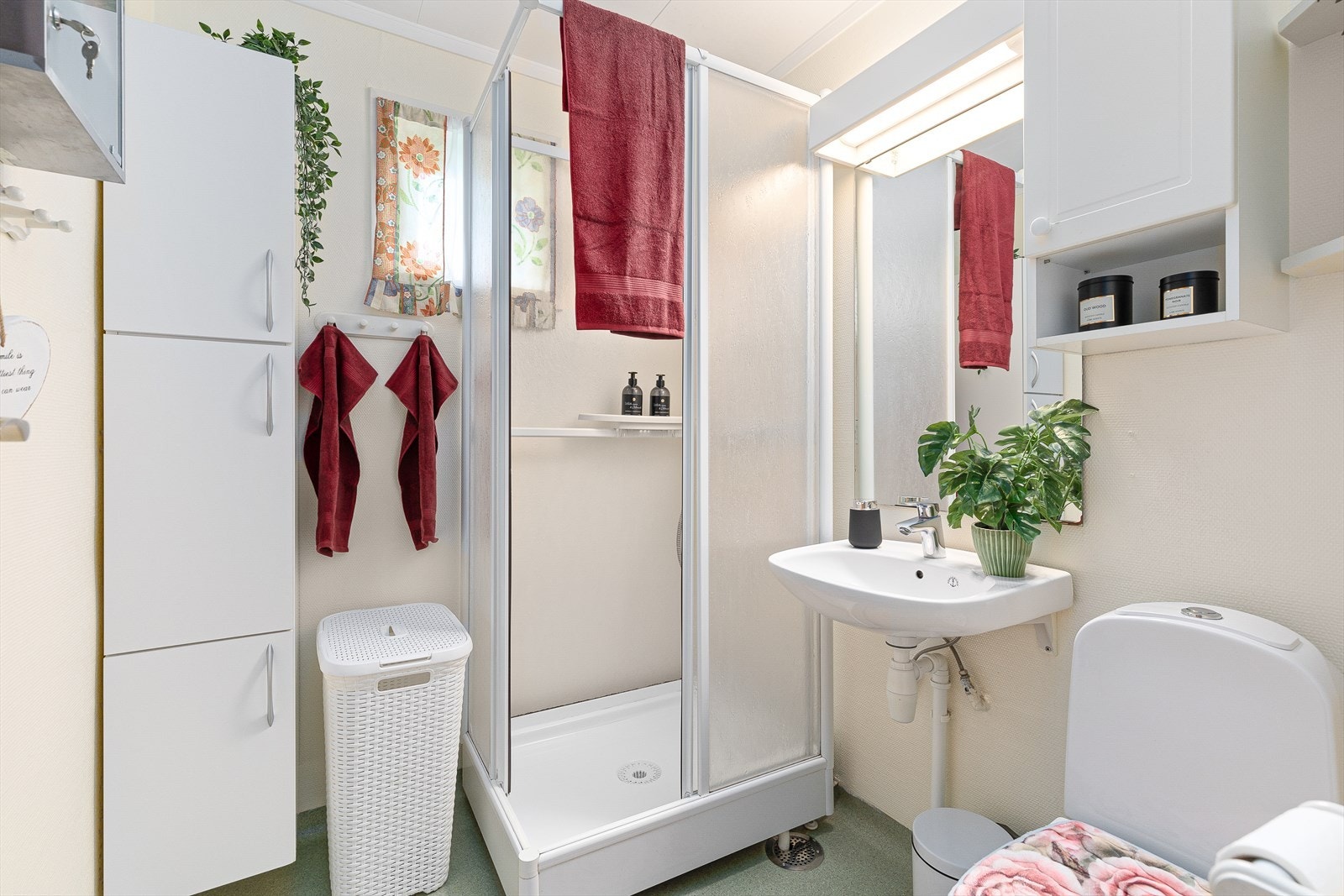 Baderommet har våtromstapet på veggar og belegg på golv. Badet er utstyrt med dusjkabinett, wc og servant, samt belyst speil på vegg. Galleribilde