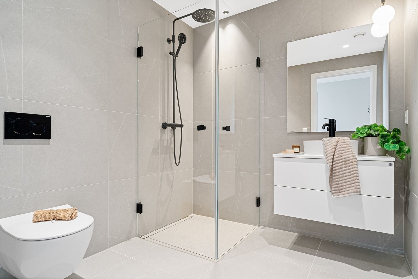 Badet er innredet med servant med 80 cm underskap, dusjhjørne i glass og vegghengt toalett. Galleribilde