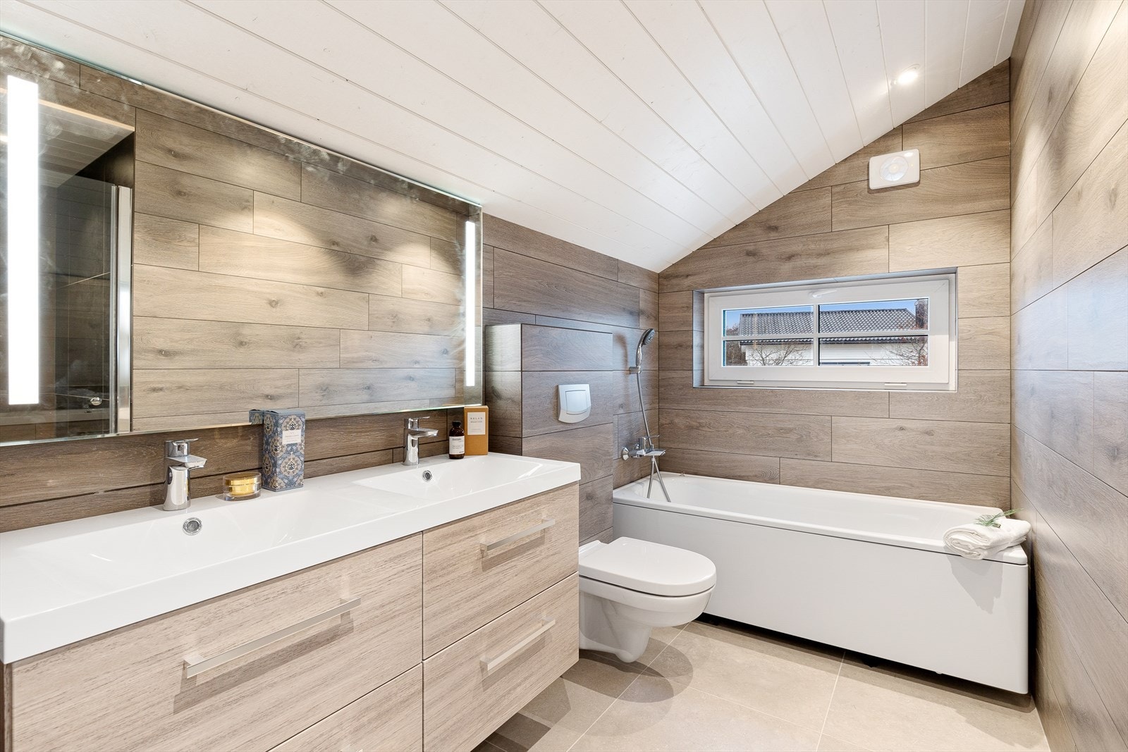 Badet i loftsetasjen har veggmontert toalett, badekar og dusjnisje. Galleribilde