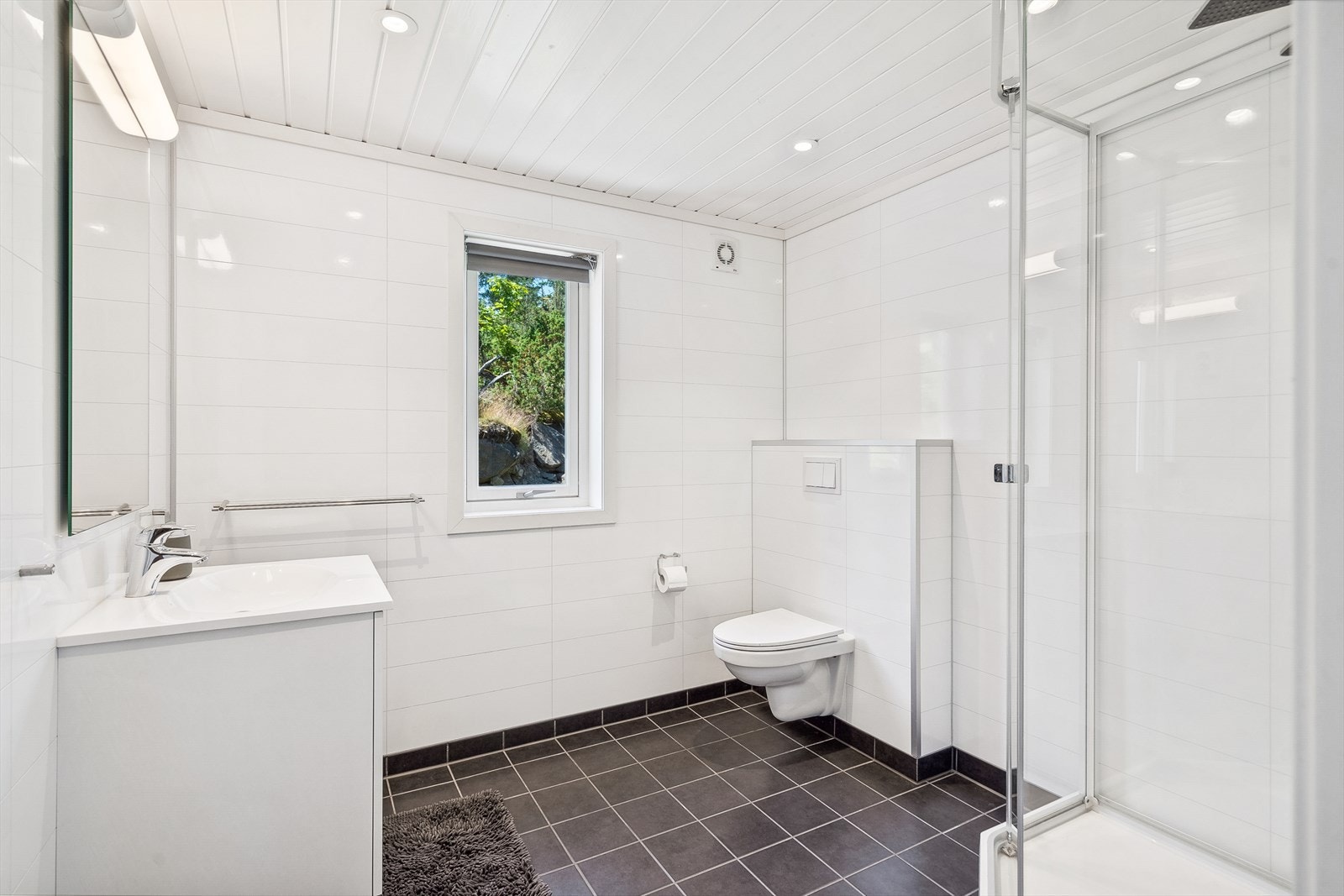 Pent og tidløst bad med dusjkabinett, vegghengt wc og innredning med vask. Galleribilde