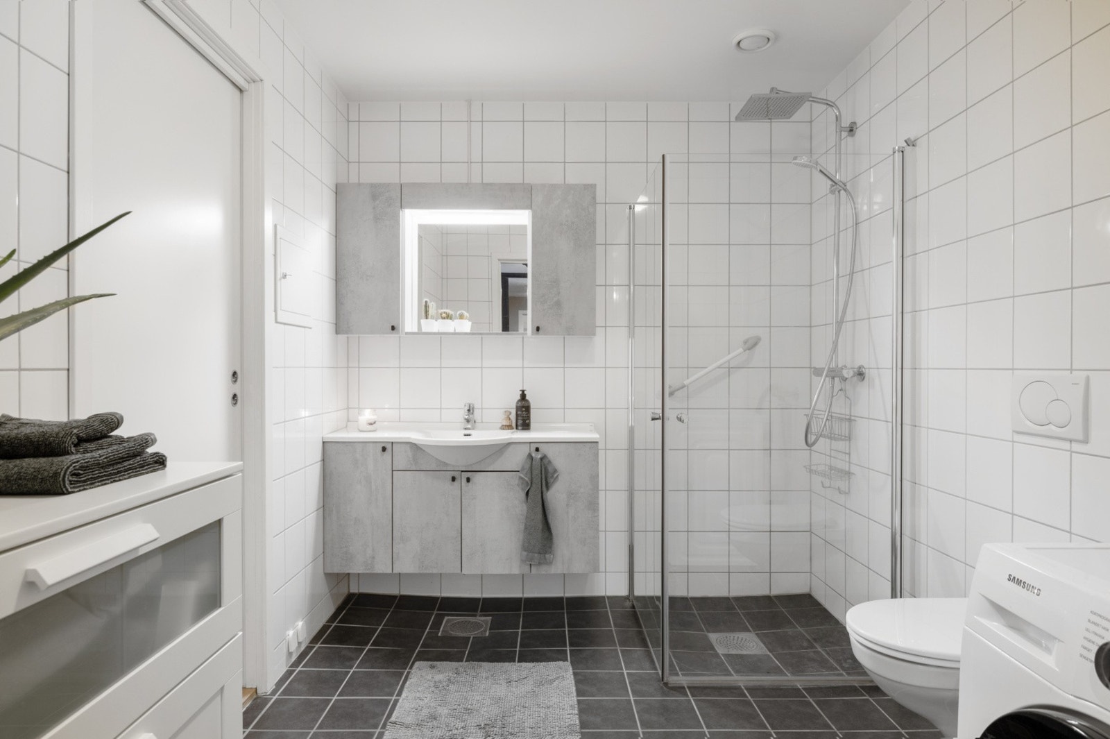 Badet måler 6 kvm. og er flislagt med varme i gulvet. Badet er utstyrt med innfellbart dusjhjørne, regndusj, opplegg til vaskemaskin samt servant med tilhørende speil og mye skapplass. Galleribilde