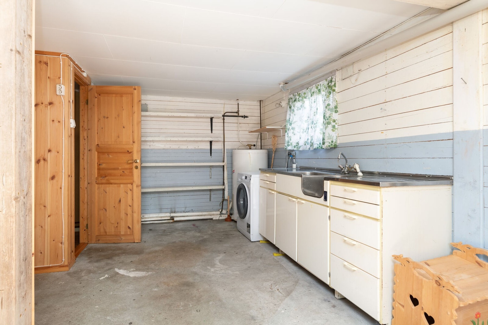 Disponibelt rom med enkel innredning og opplegg for vaskemaskin. Galleribilde