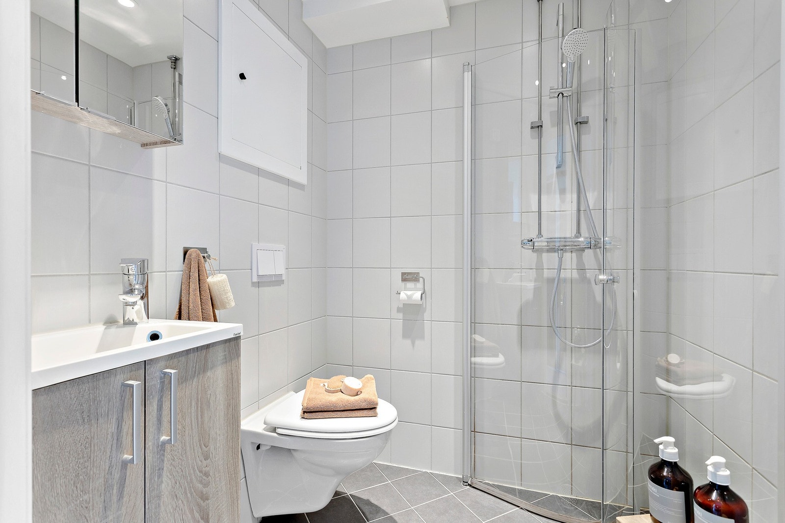Lyst og pent, flislagt baderom med varme i gulv og downlightsbelysning i taket. Badet ble pusset opp i regi av borettslaget i 2017. Galleribilde