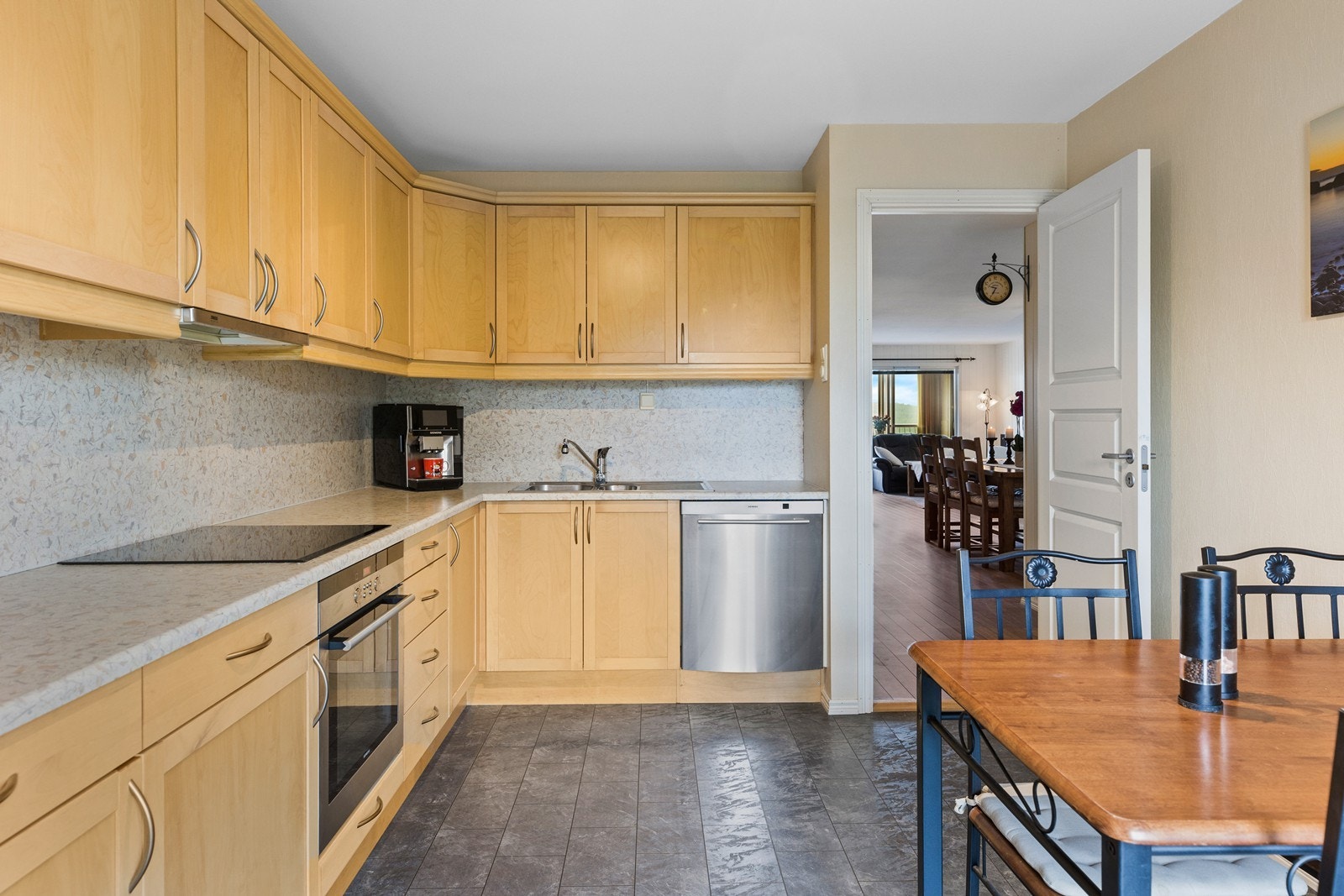 Innholdsrikt kjøkken som består av profilerte over-/underskap og laminert benkeplate. Galleribilde