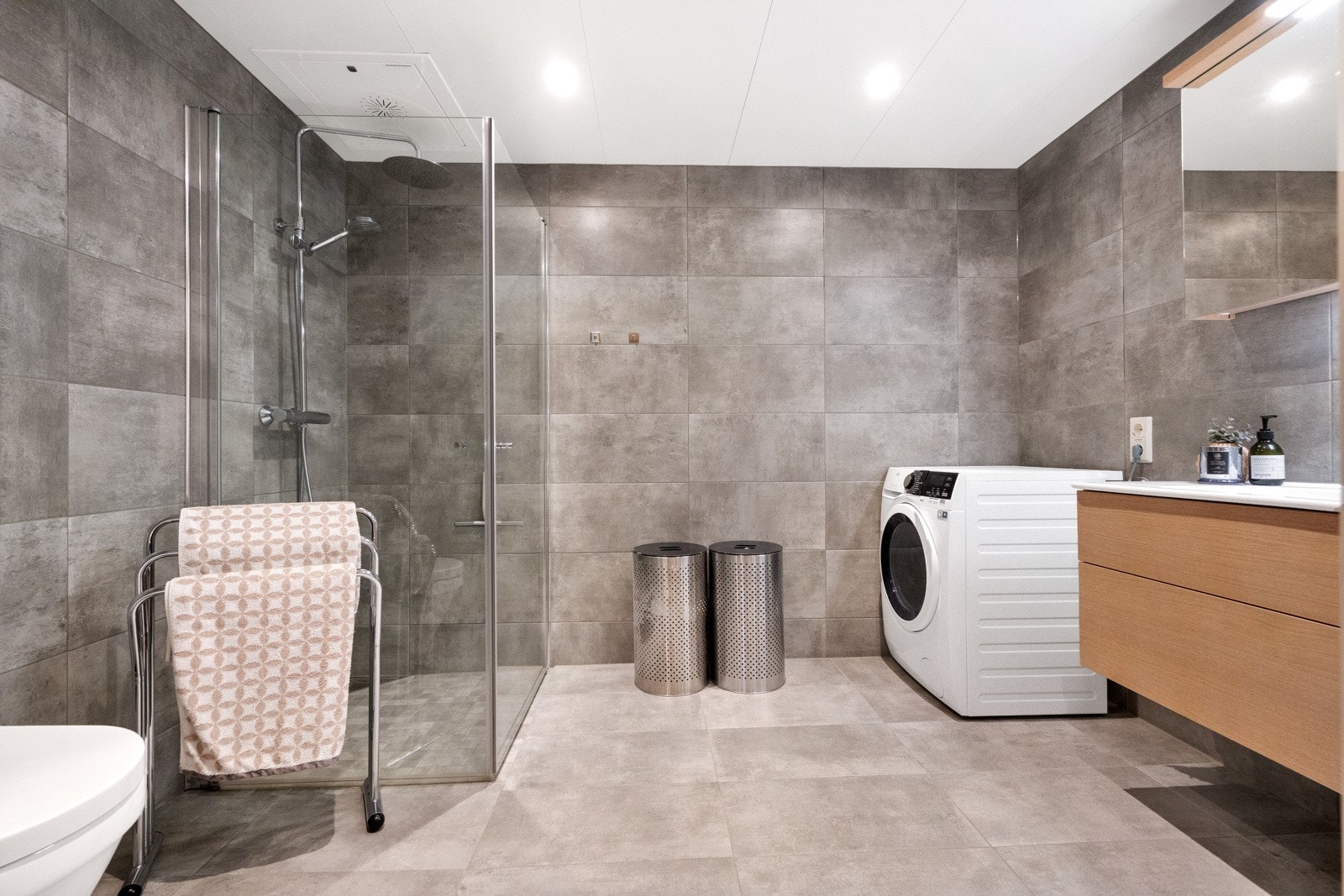 Innbydende, flislagt bad med opplegg for vaskemaskin Galleribilde