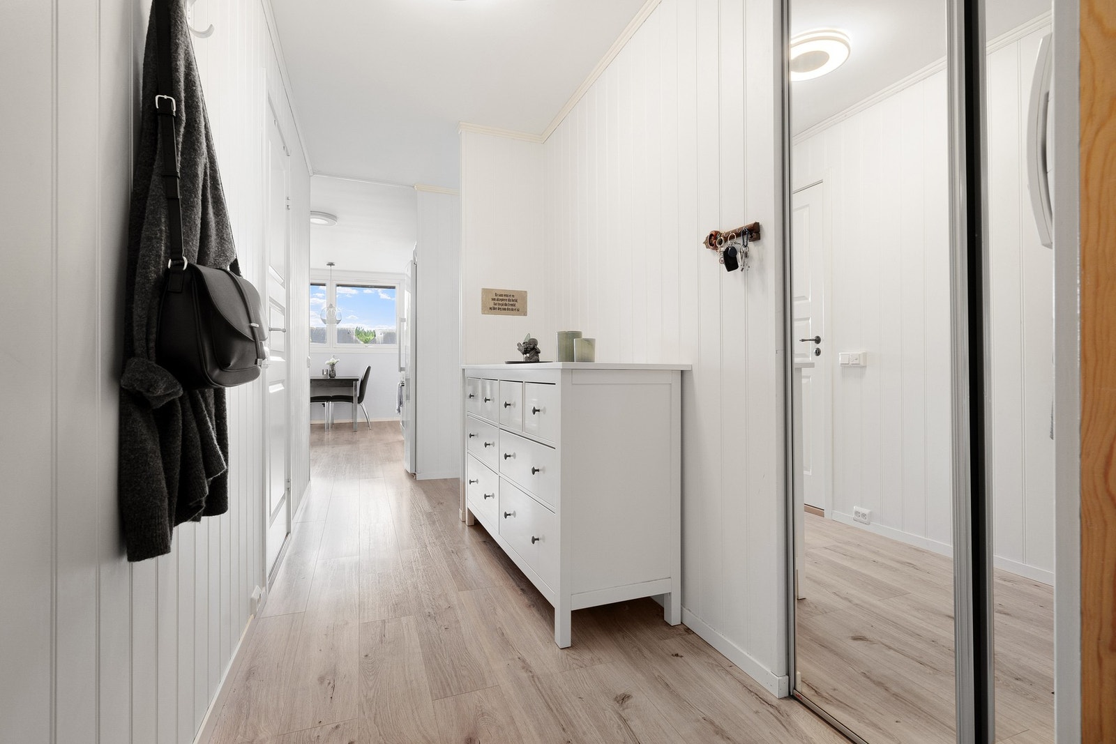 Lys og innbydende entré med praktisk skyvedørsgarderobe. Galleribilde