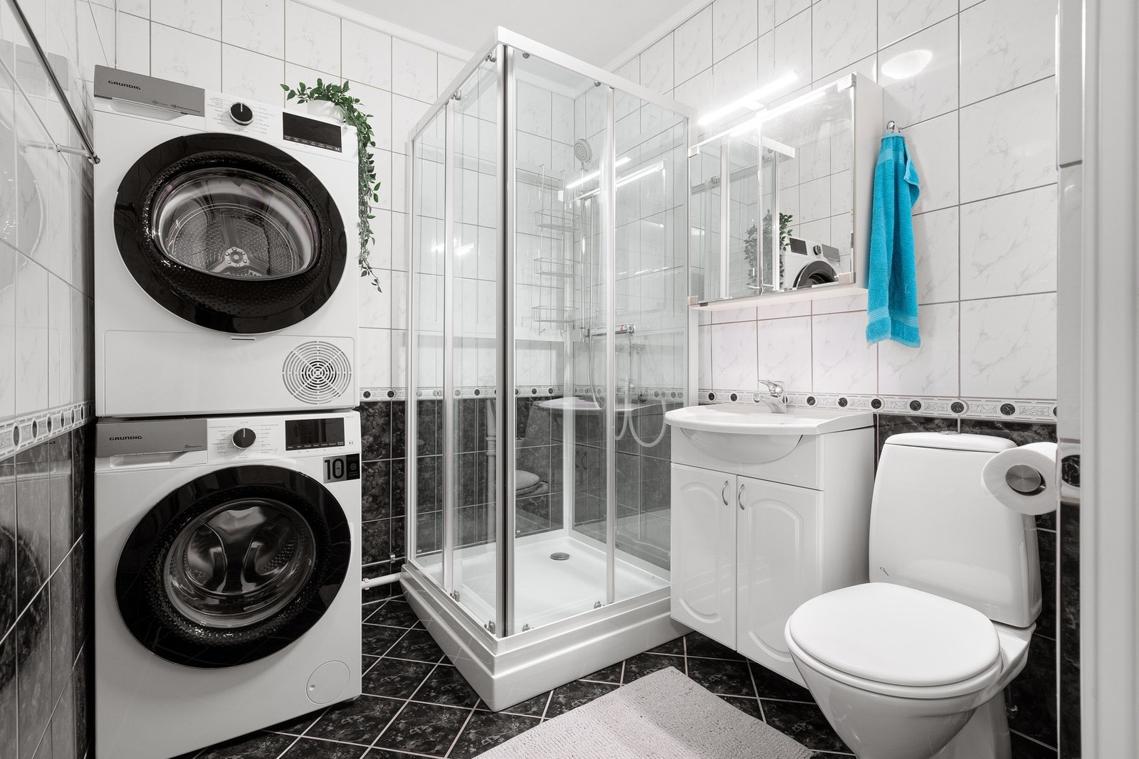 Flislagt baderom med opplegg for vaskemaskin. Galleribilde