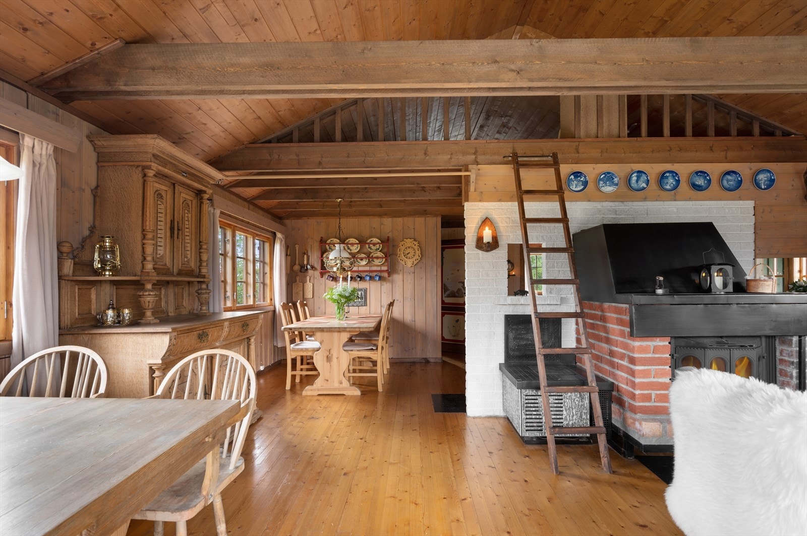 I stua er det en flott peis med innsats, samt en tradisjonell vedovn ved kjøkkenet. Over deler av hytta finner vi hemsen med stige fra stua. Galleribilde