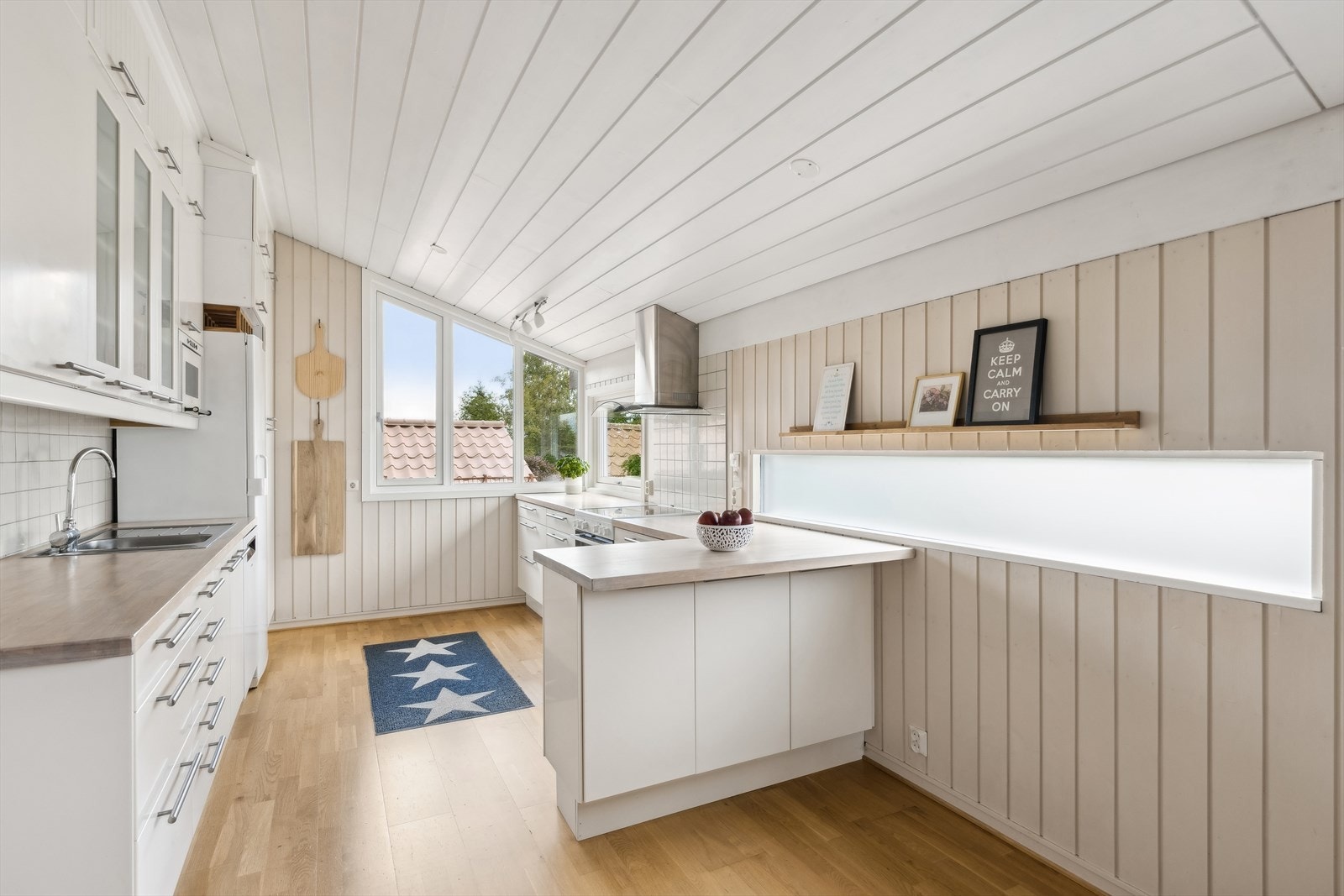 Kjøkkenet har slette, lyse fronter og benkeplater i eik. Galleribilde