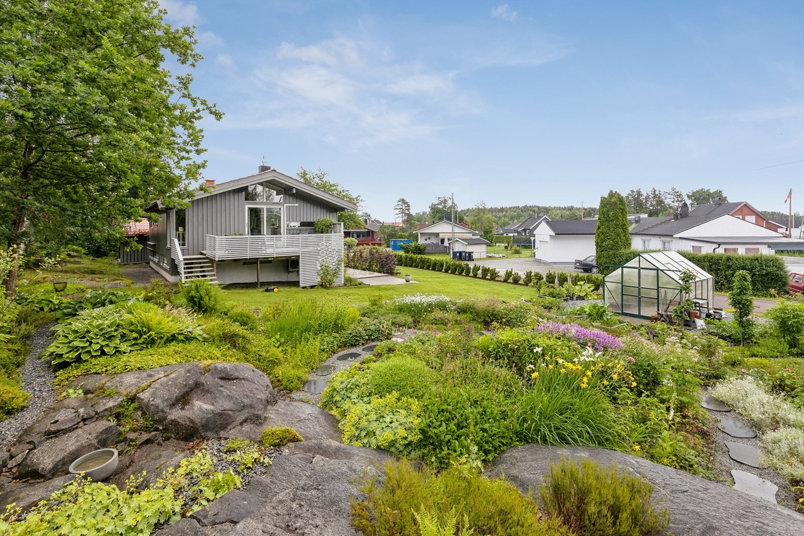 Tomten er pent opparbeidet med gressplen, hekk og meget pent anlagt hage. Galleribilde