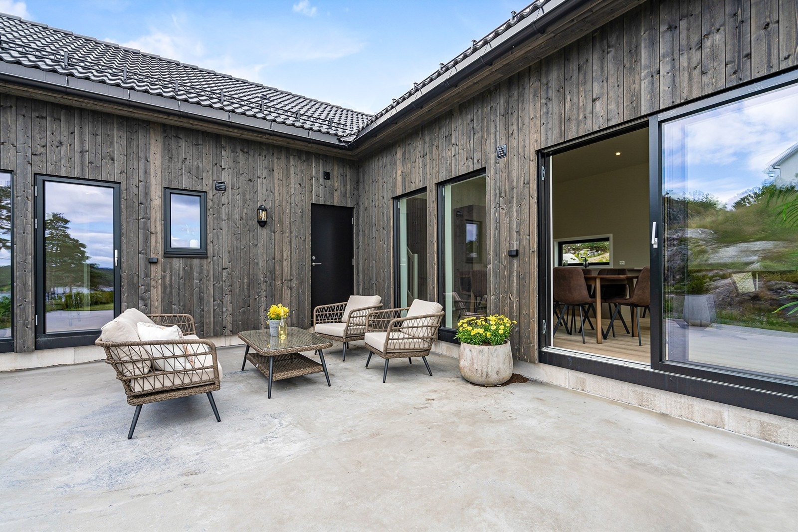 Solrik terrasse utenfor stue. Dør til toalett midt i bildet. Galleribilde