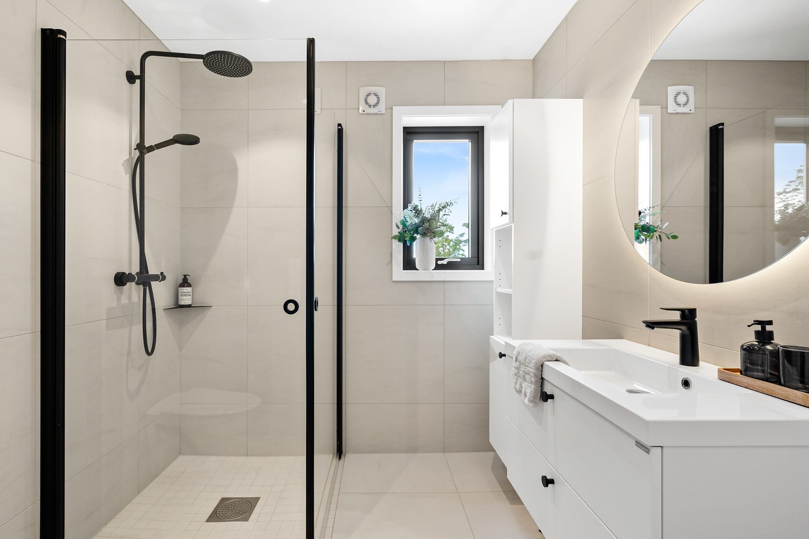 Badet i 1. etg. Dusjhjørne, servant med skuffer under, høyskap og vegghengt wc. Galleribilde