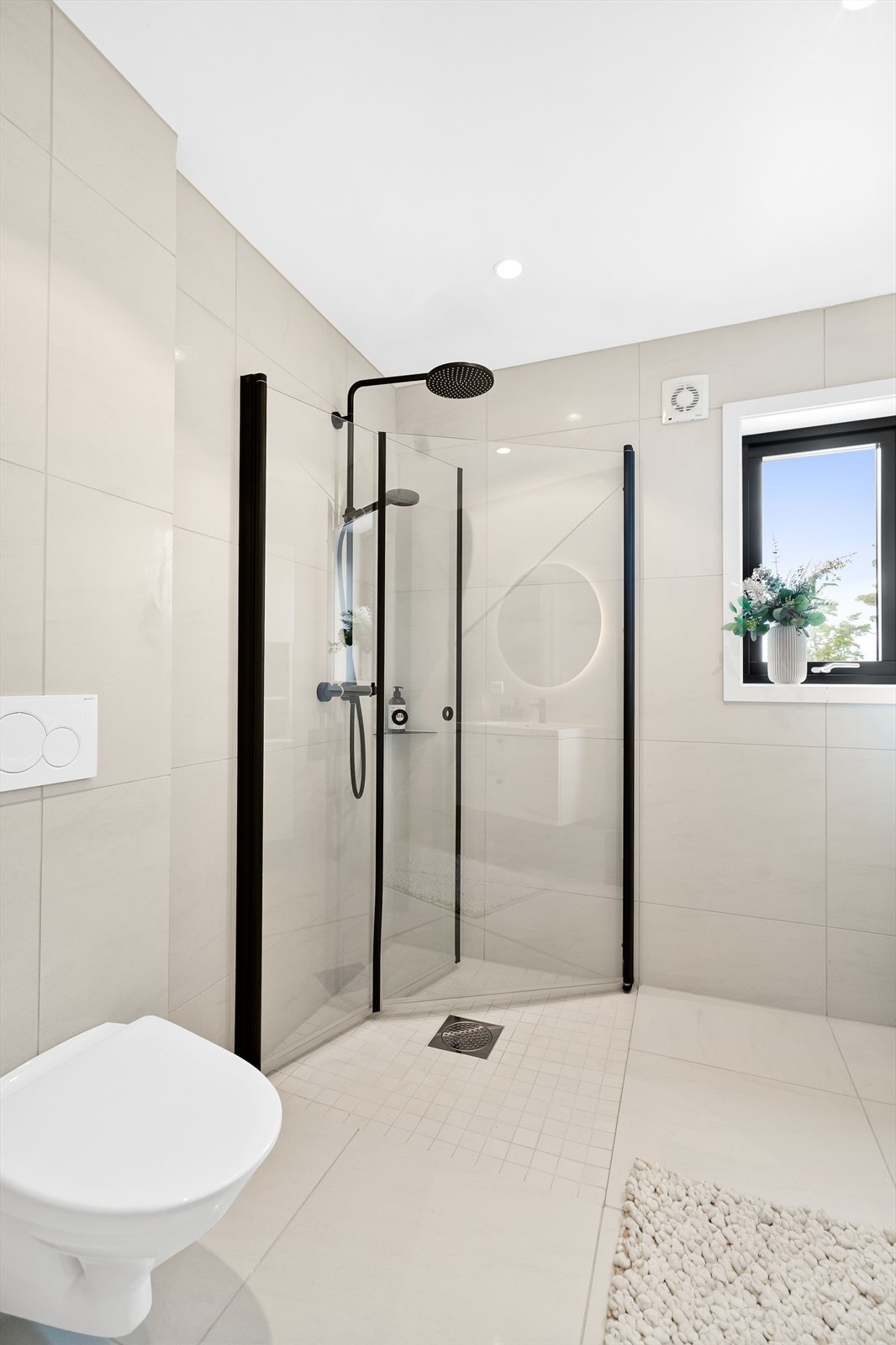 Badet i 1. etg. Dusjhjørne, servant med skuffer under, høyskap og vegghengt wc. Galleribilde