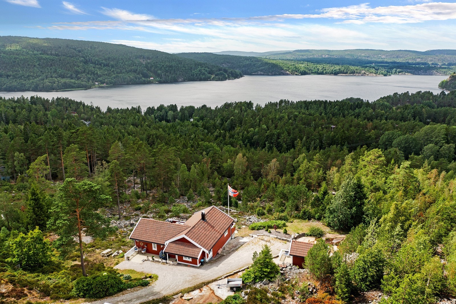 Dronefoto mot hytta og sjøen Galleribilde