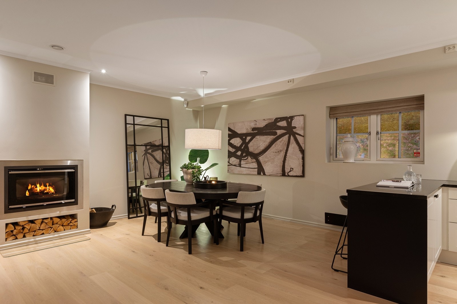 Den lekre peisen er plassert mellom stuen og spisestuen og gir rommet en lun og hyggelig atmosfære Galleribilde