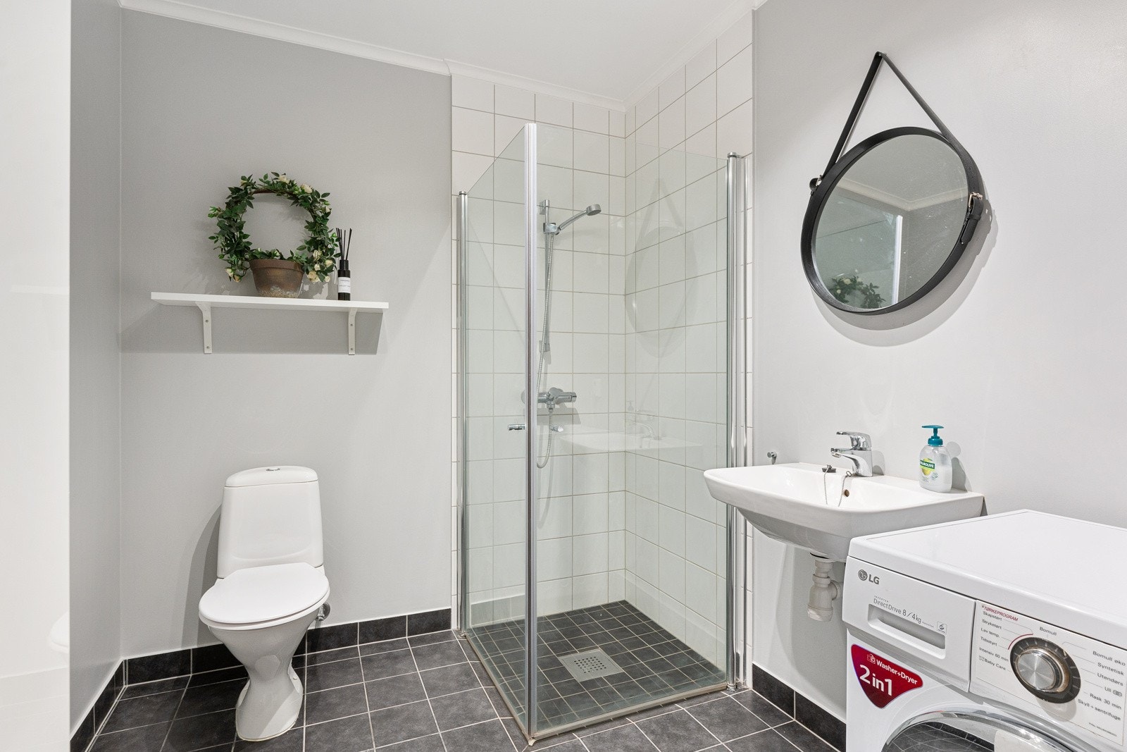 Baderommet er flislagt og har behagelig gulvvarme. Innredningen består av toalett, servant og dusj med innfellbare glassdører Galleribilde