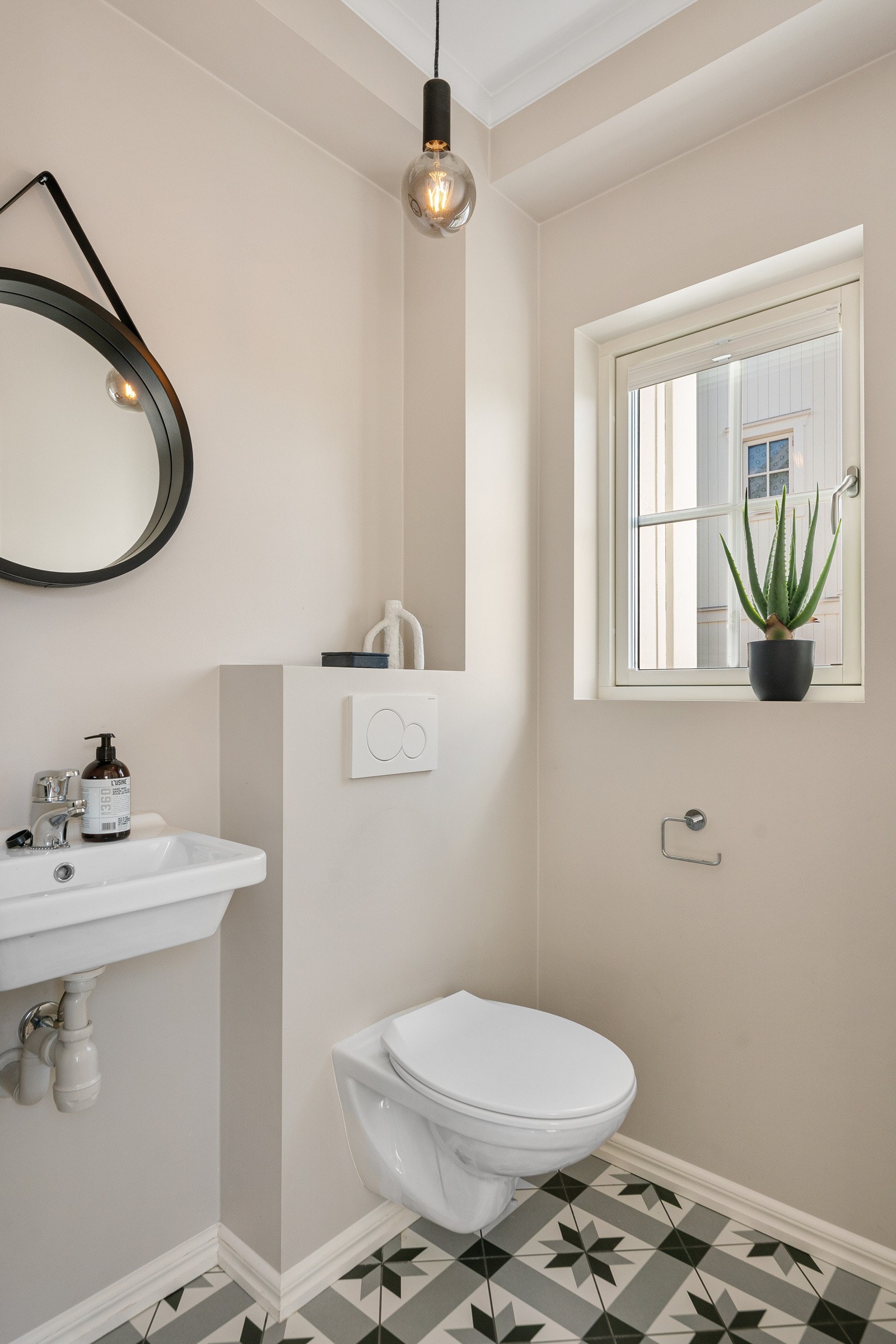 Praktisk og pent toalettrom med flislagte overflater og behagelig gulvvarme. Toalettrommet inneholder vegghengt toalett med innebygget sisterne med sensor tilknyttet waterguard, vegghengt porselenservant, med ettgreps servantarmatur, speil og taklampe Galleribilde