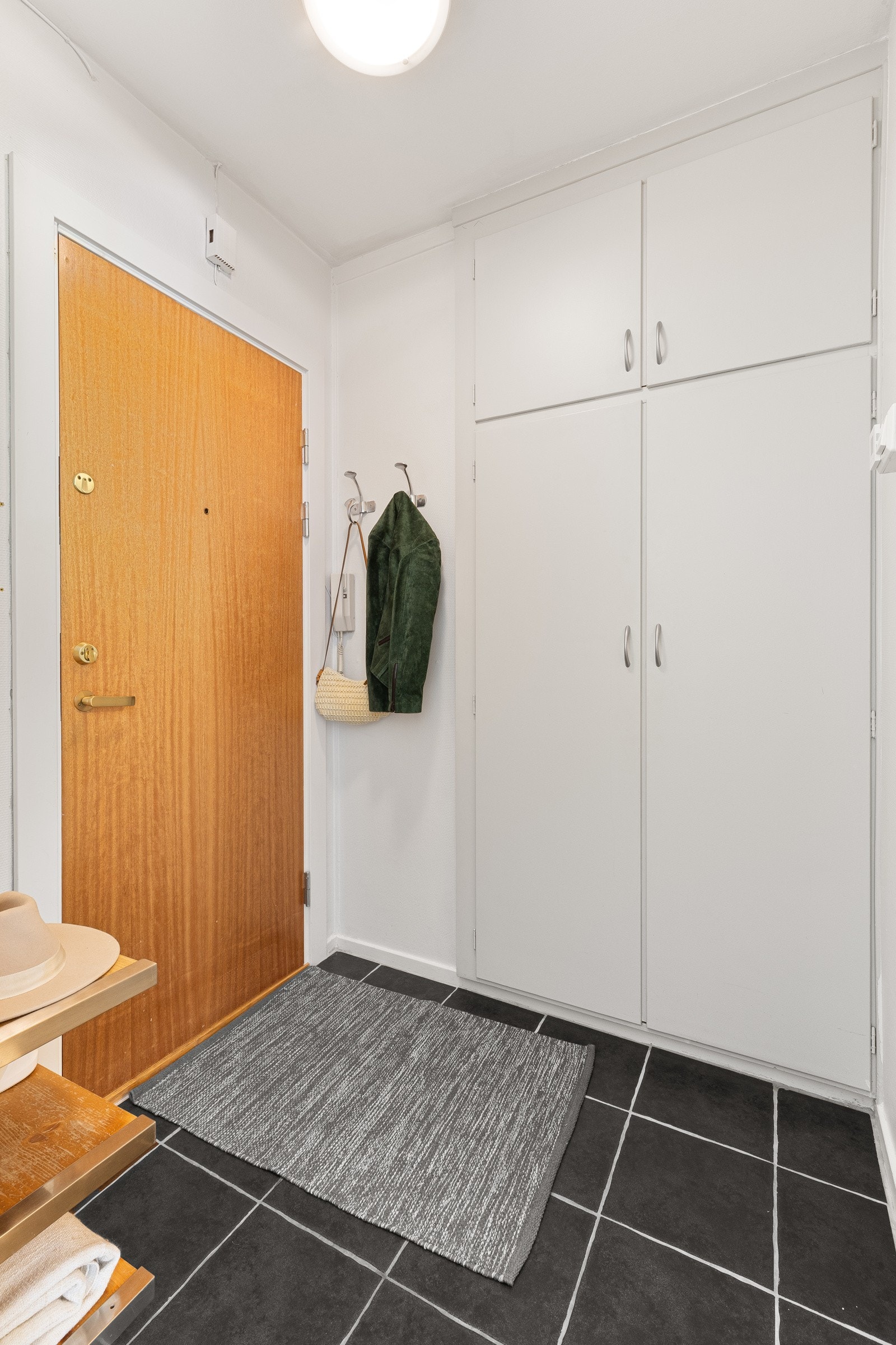 Her er det innebygd klesskap og hyller til å sette sko. Fliser på gulv. Galleribilde