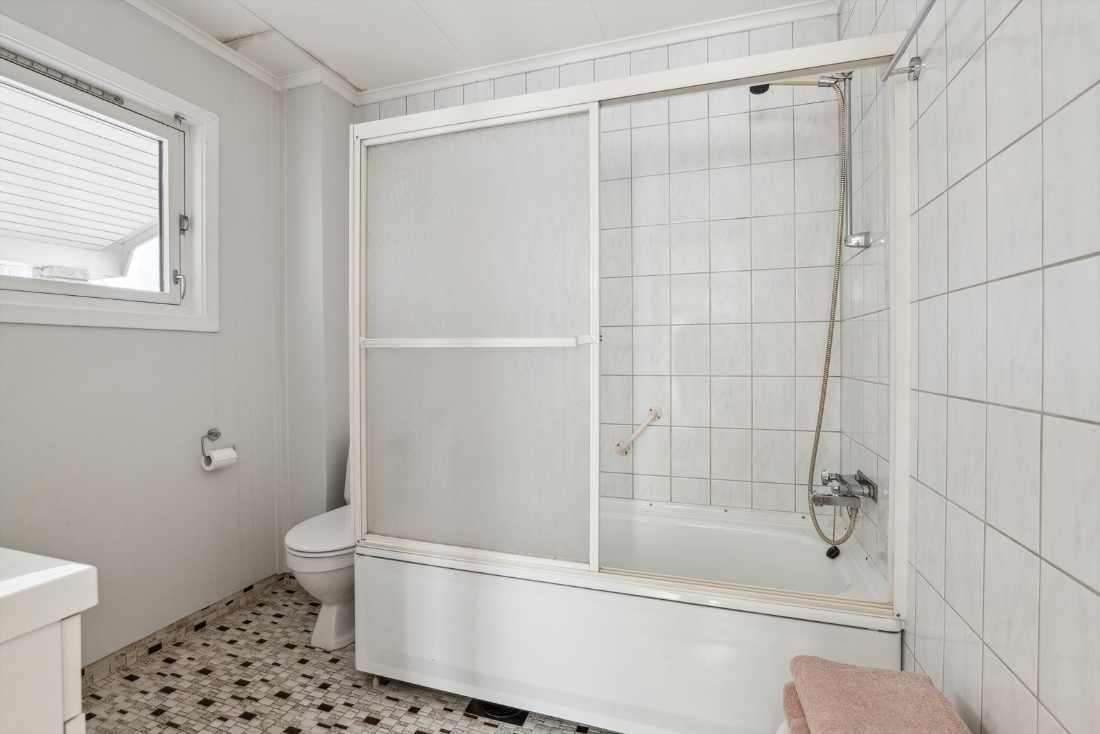 Badet i 1.etasje har flislagt gulv med varmekabler og fliser/våtromsplater på vegger. Innredet med badekar, wc og innredning med servant. Galleribilde
