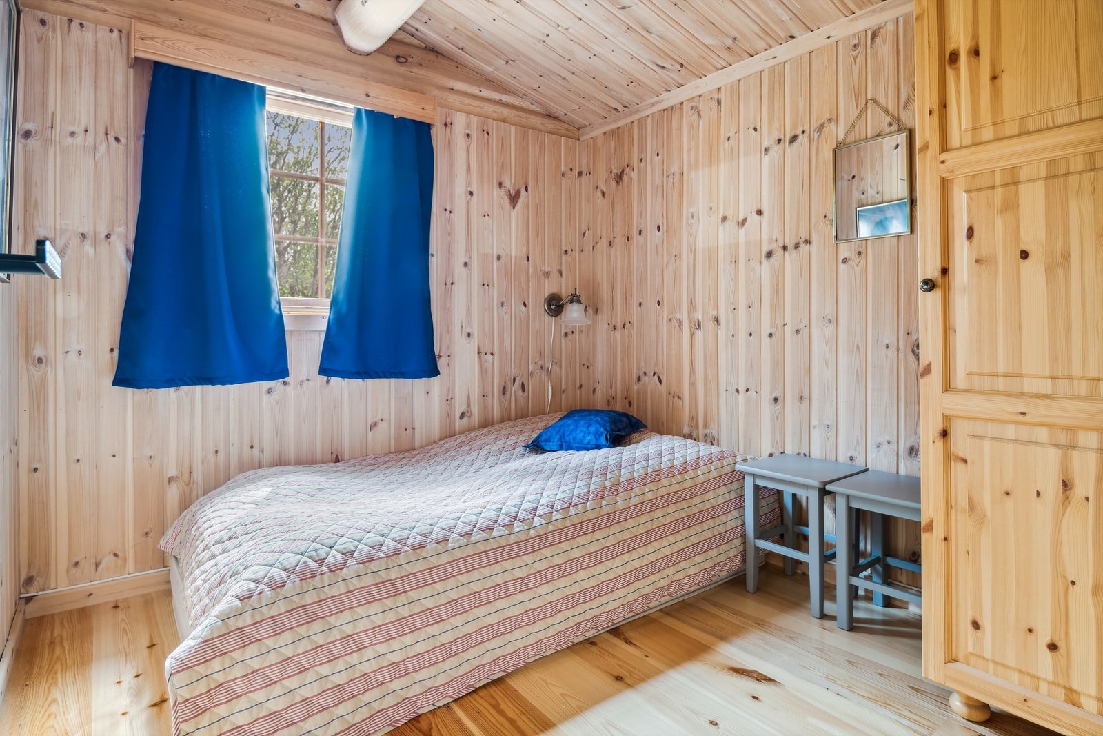 Det andre soverommet har panel på veggene og furugulv. Rommet er romslig og innredet med garderobeskap. Her kan du sove godt om natten, og lufte gjennom vindu på morgenen. Galleribilde