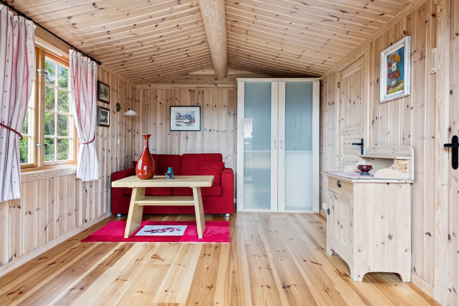 Stuen i annekset har panel på veggene og furugulv. Her er det mulig å innrede med sofagruppe, skap, kommode og annet stuemøblement. Galleribilde