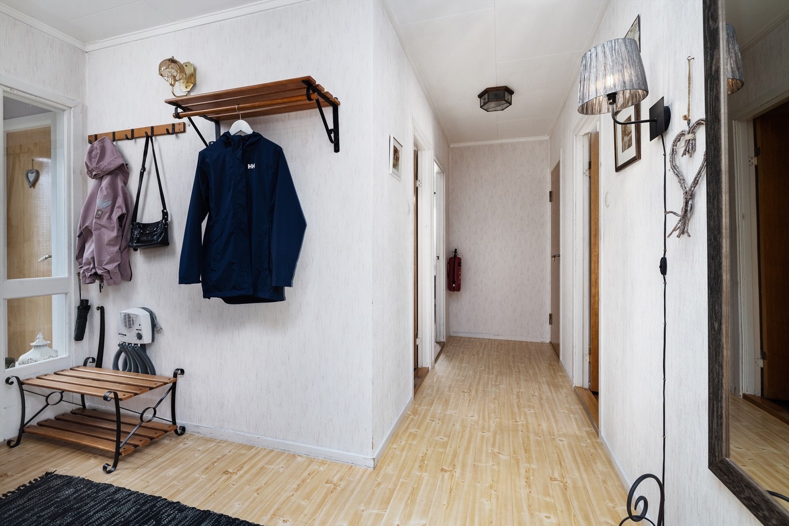 En lys og luftig gang med plass til å henge fra seg yttertøy. Galleribilde