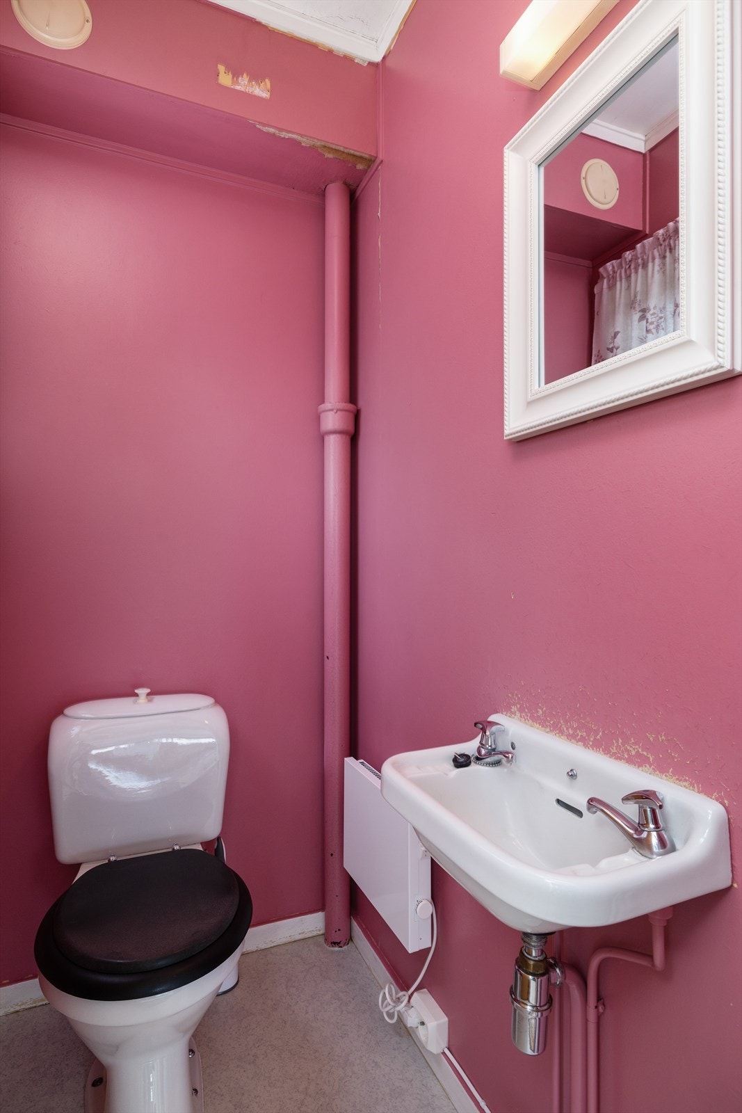 Toalettrom med veggehengt servant og toalett. Galleribilde