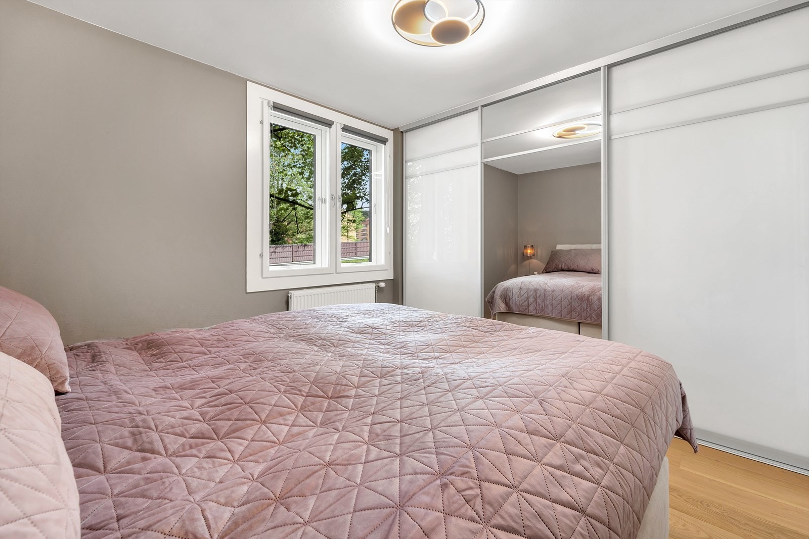 Klær og øvrig tilbehør får du fin plass til i en praktisk skyvedørsgarderobe med slette fronter og speil. Galleribilde