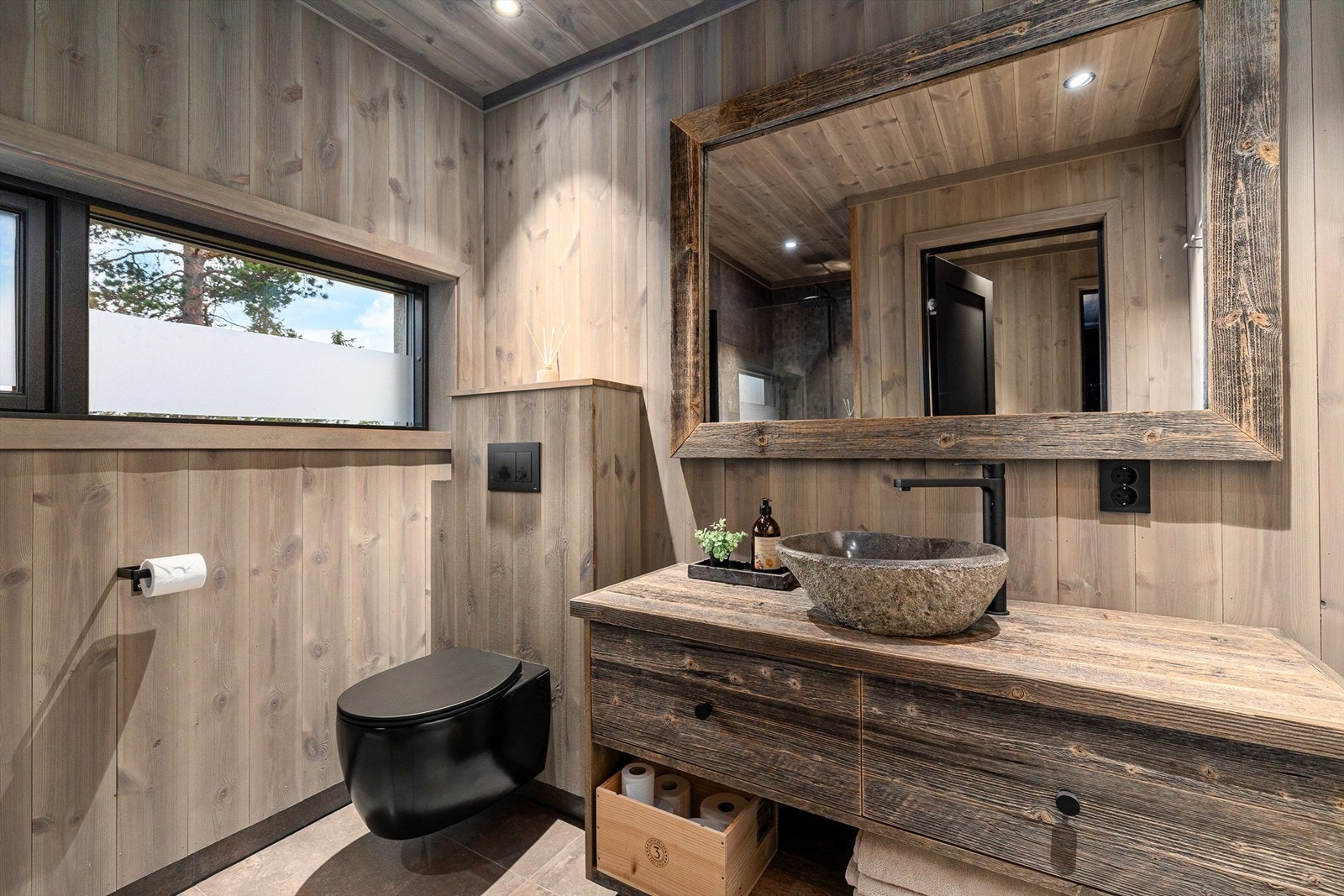 Badene har røffe og håndlagde baderomsinnredning fra Drivved.no, med servantskap, runde steinvasker og speil. Galleribilde