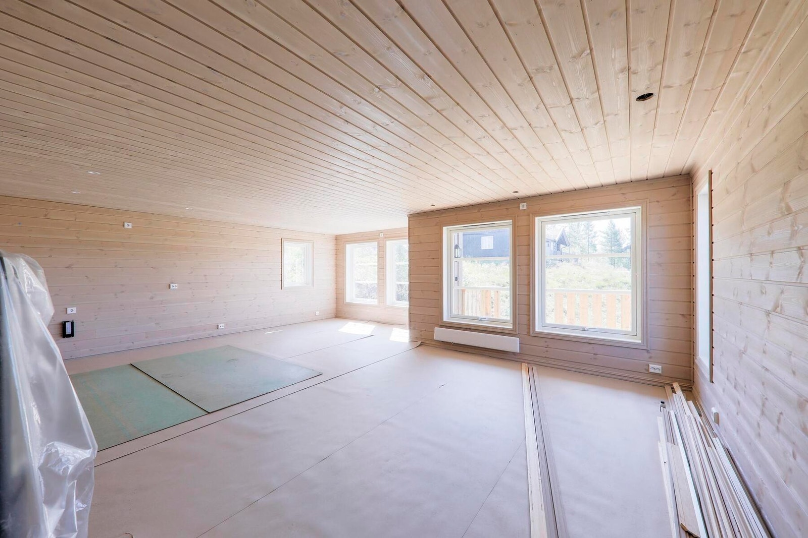 Romslig stue med store vindusflater. Byggeplassfoto. Galleribilde