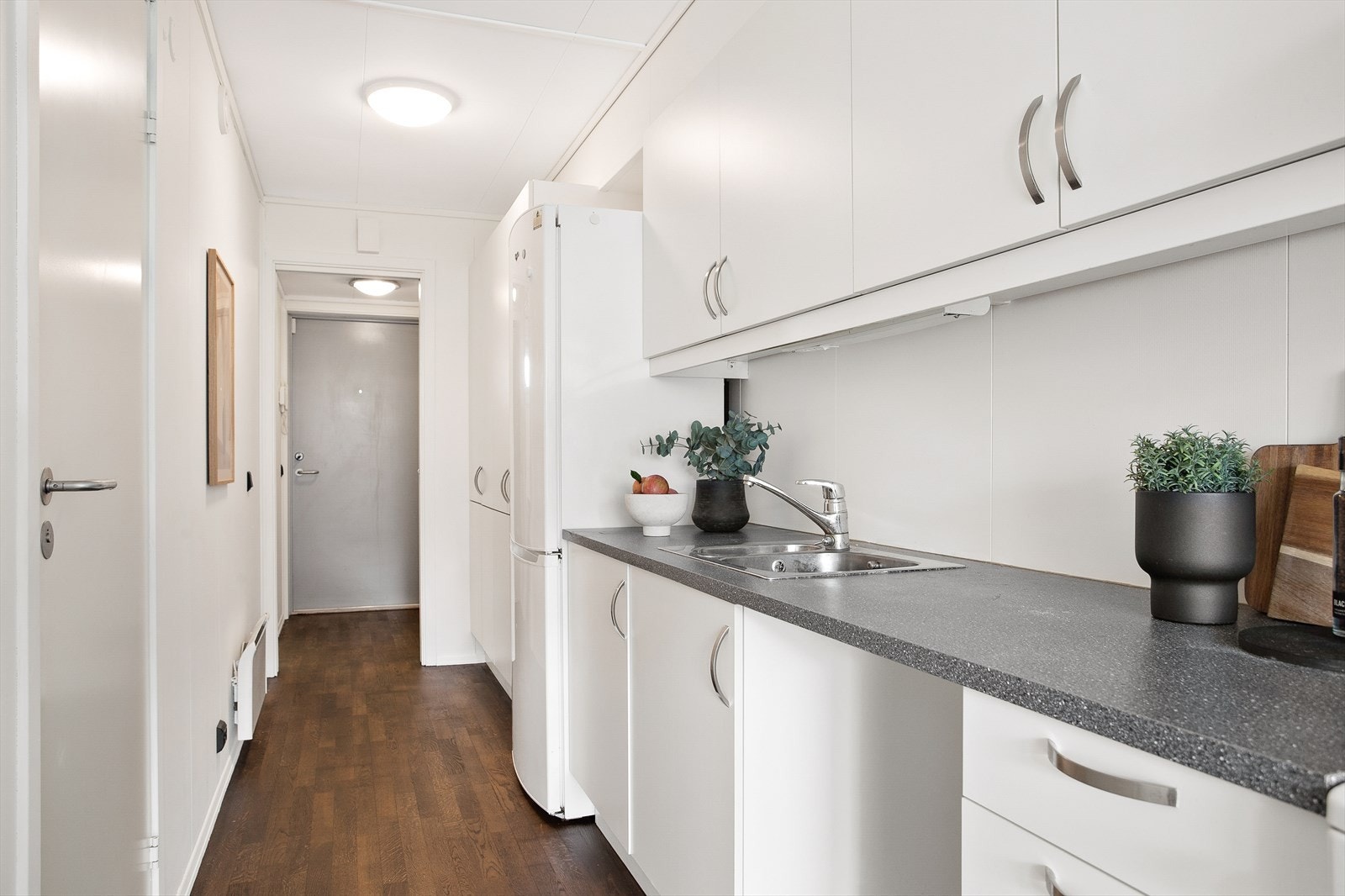 Hvit, glatt kjøkkeninnredning med laminat benkeplate Galleribilde