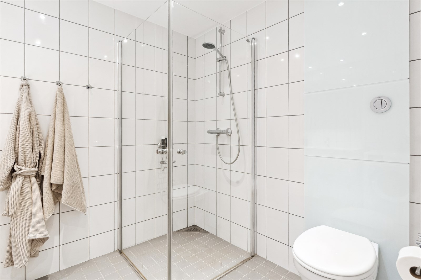 Flott flislagt bad med varme i gulv og downlights i tak. Galleribilde