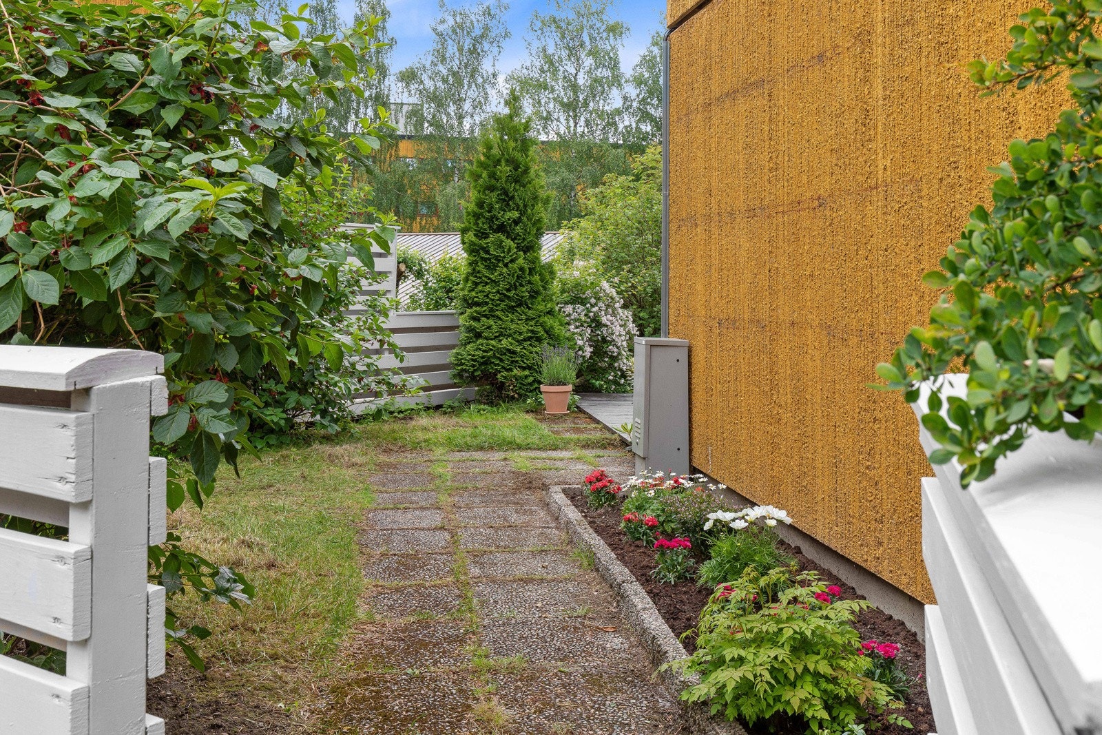 Hagen er inngjerdet og det er port i gjerdet slik at barna kan løpe fritt ut for å leke Galleribilde