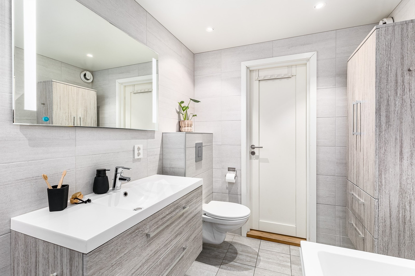 Badet ble renovert i 2016 og helhetlig utført med fliser i grå nyanser på gulv og vegger. Gulvet har også varme. Galleribilde