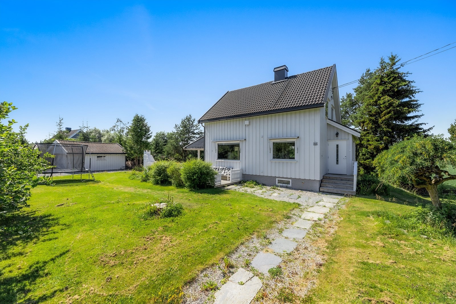 En passasje av skiferheller leder til et trivelig inngangsparti med trapp Galleribilde