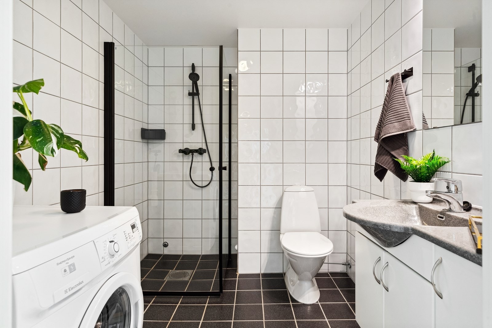 Badet er utstyrt med WC, dusj og servant, samt opplegg for vaskemaskin Galleribilde