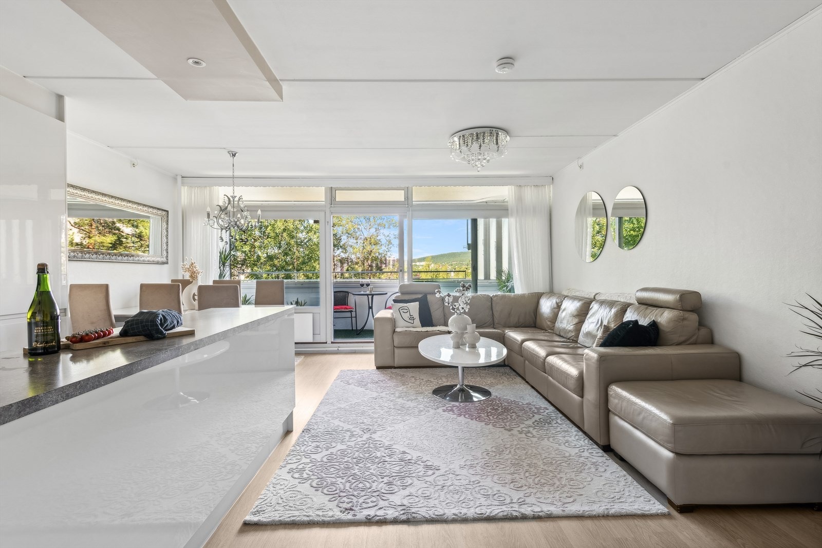 Stue med åpen kjøkkenløsning. Rommet er malt i lyse- og behagelige veggfarger. Galleribilde