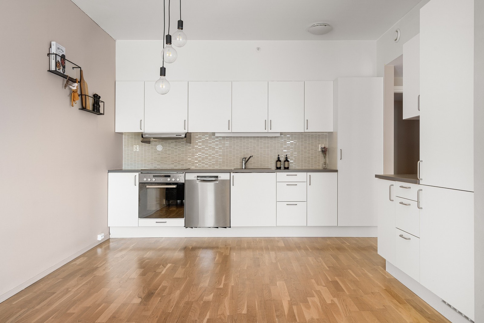 Lyst og moderne kjøkken med mye skap- og benkeplass. Galleribilde