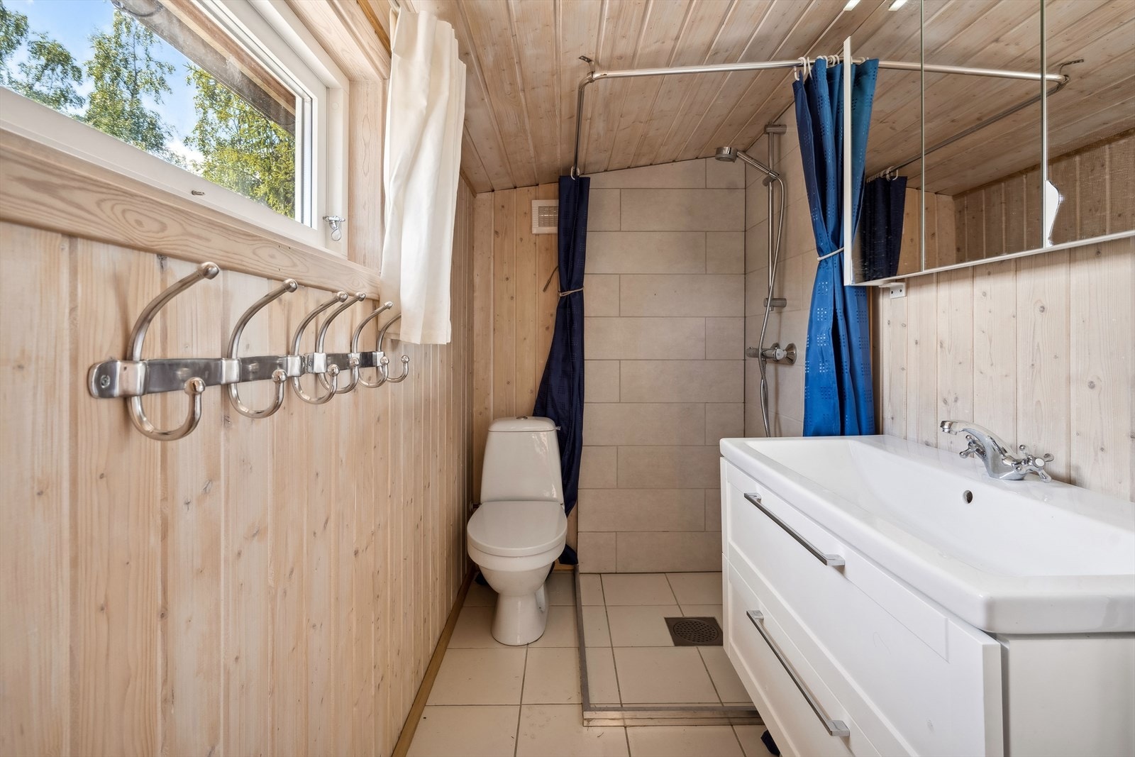 Badet ligger også i tilbygget (ikke godkjent) og er utstyrt med toalett, dusjhjørne og servantinnredning. Det er innlagt vann, men det er ikke godkjent av kommunen (les punktet "vei, vann og avløp" i salgsoppgaven). Galleribilde